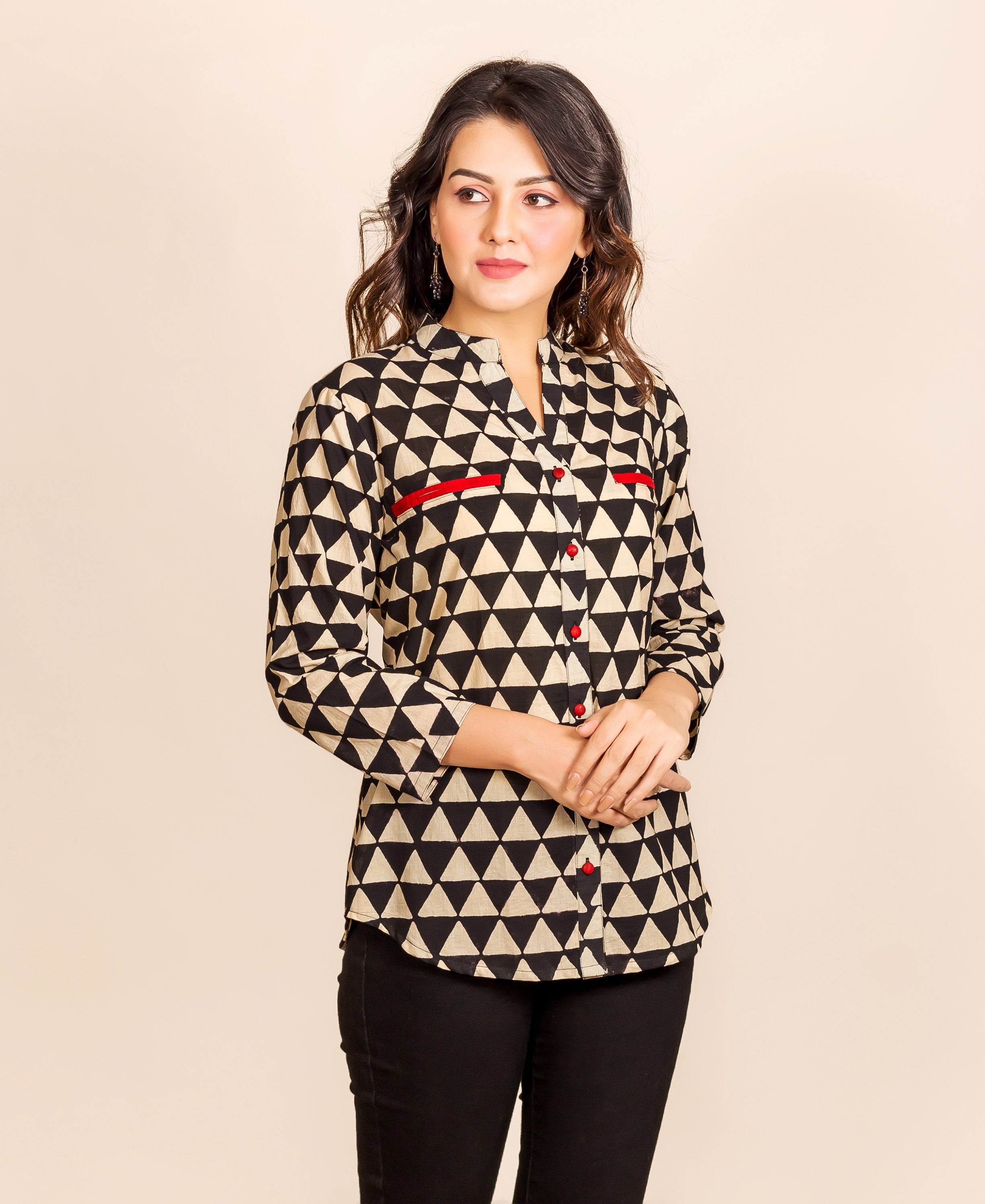 Model wearing a black and beige triangle print shirt-style top with red accents.