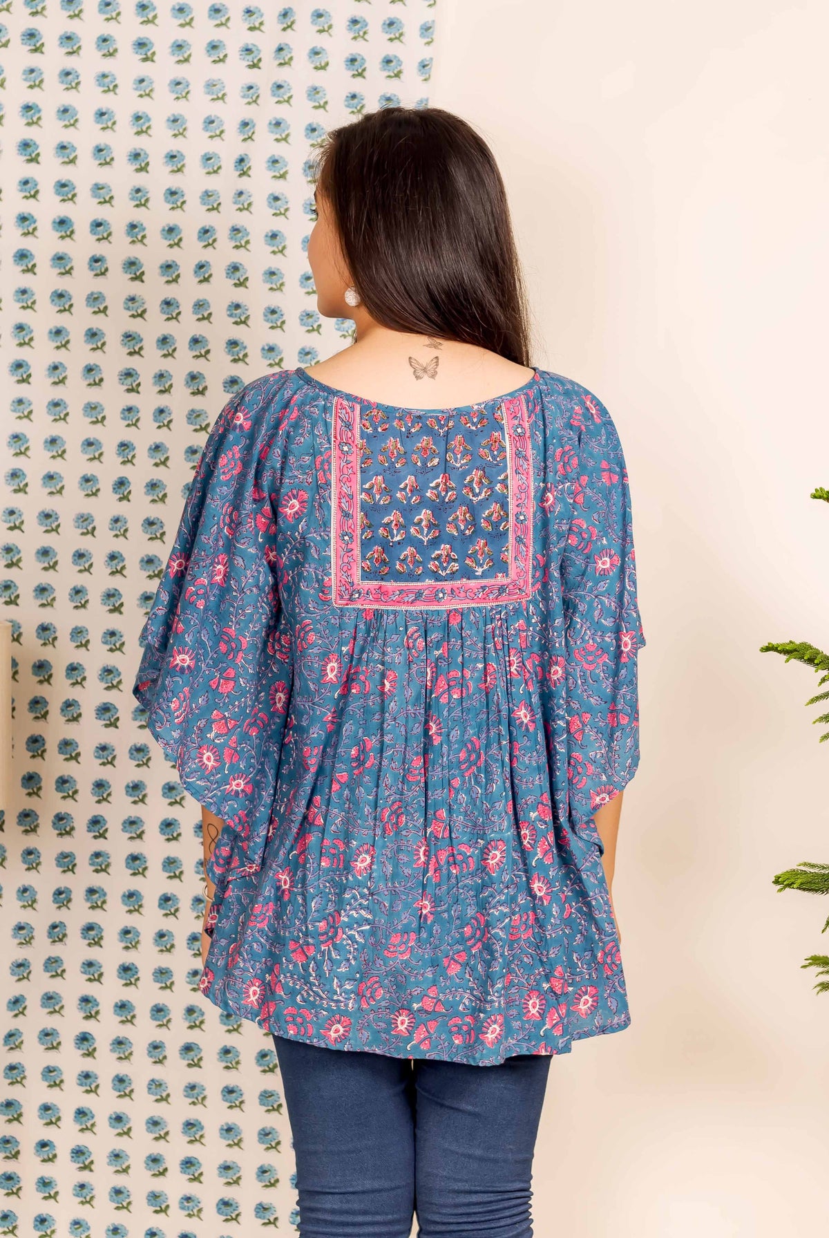 Model's back in a blue and pink hand block printed kaftan top with square yoke.