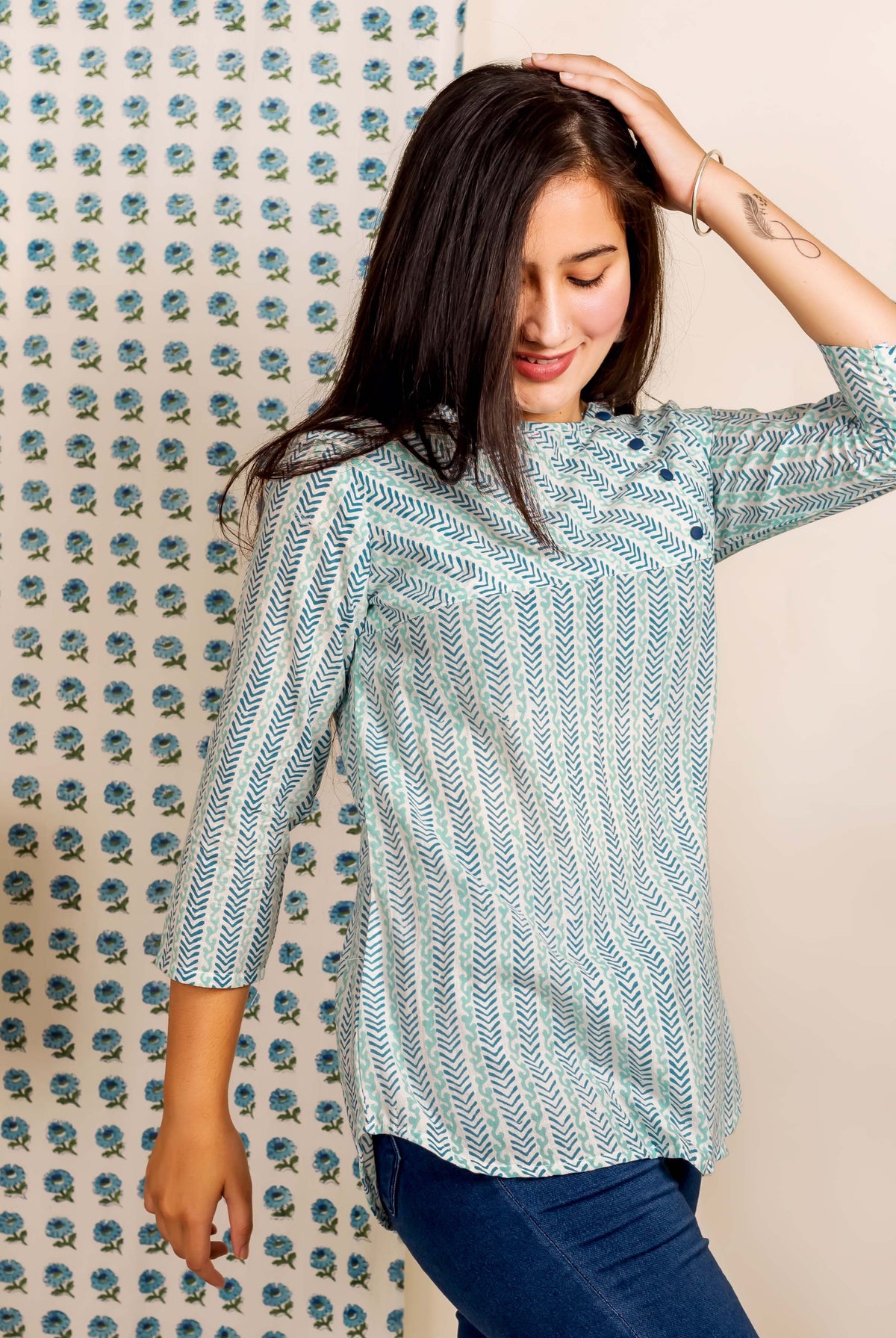 A model wearing a blue and white hand-block-printed ethnic top with a chevron pattern.