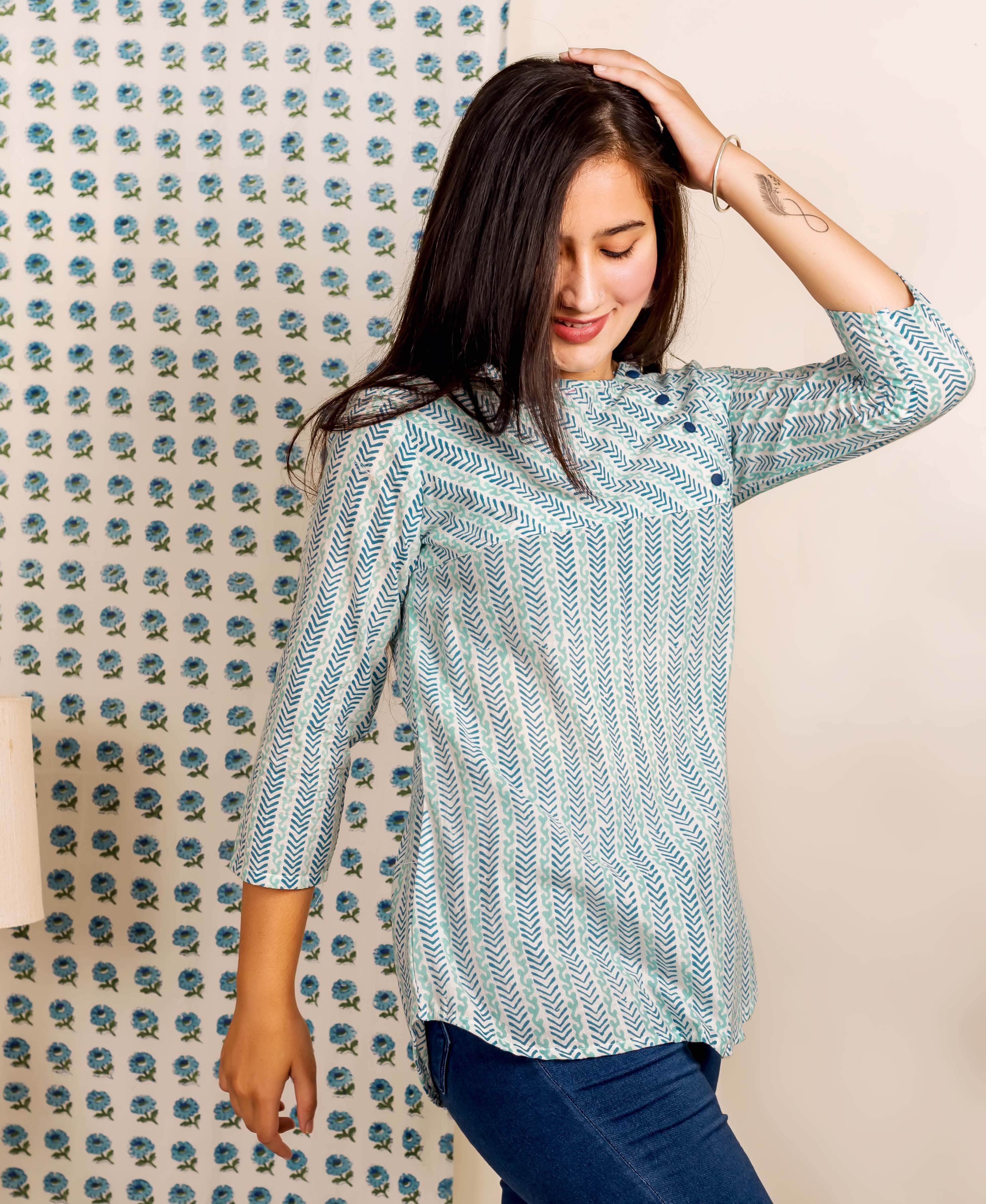 A model wearing a blue and white hand-block-printed ethnic top with a chevron pattern.