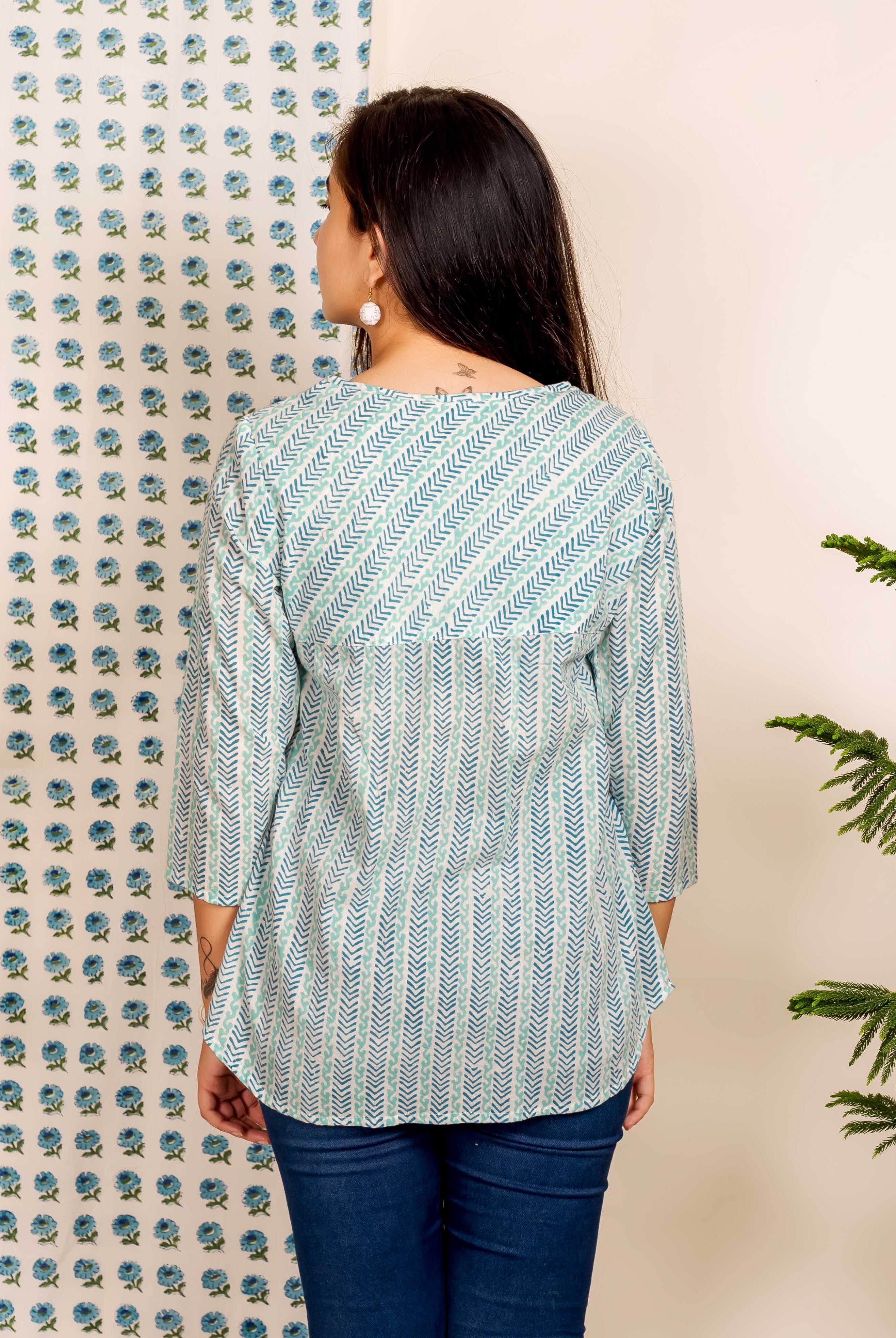 Back view of model wearing blue and white chevron hand block printed ethnic top and jeans.
