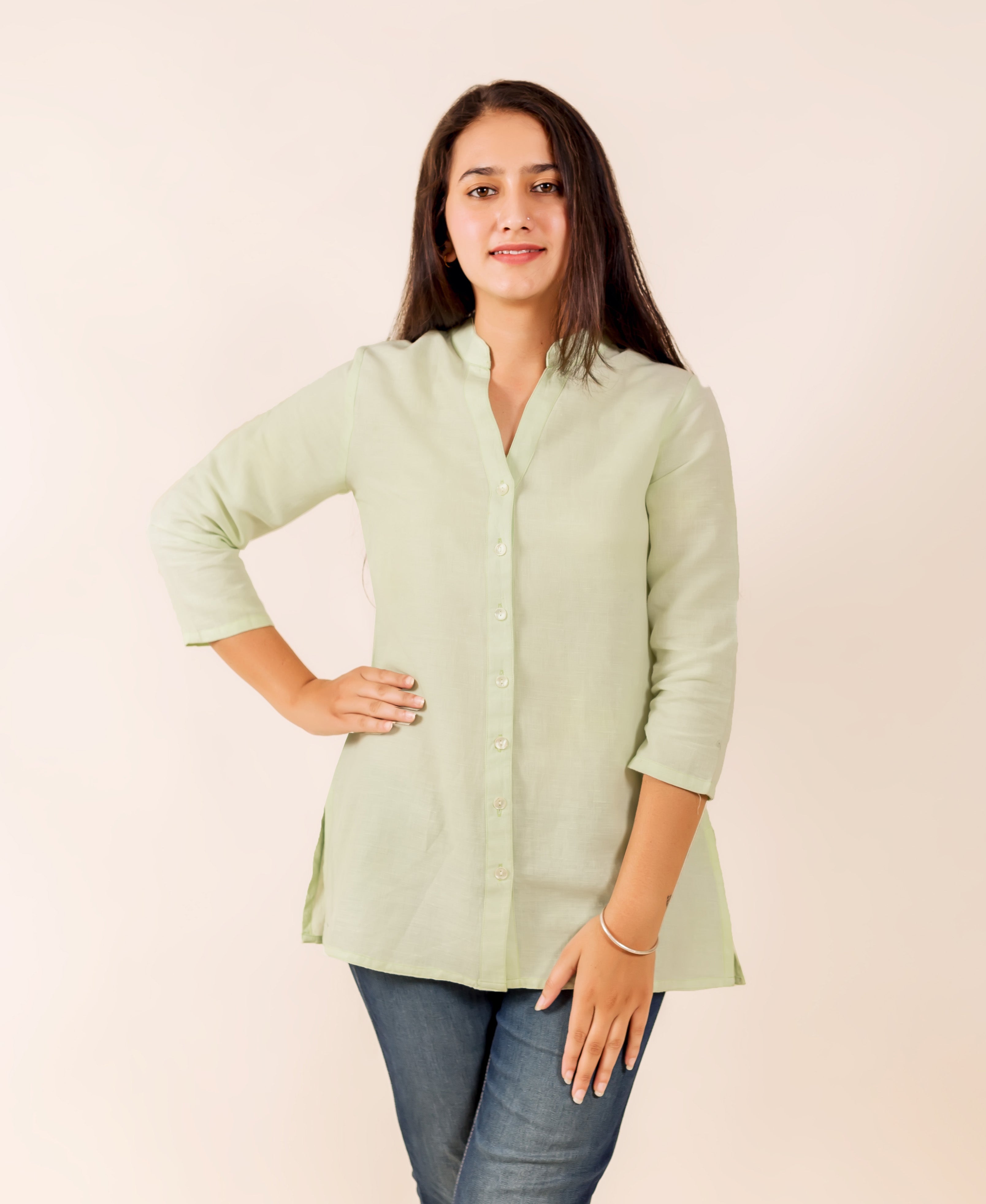 Smiling model wears a lime linen button-down top with a band collar and 3/4 sleeves.