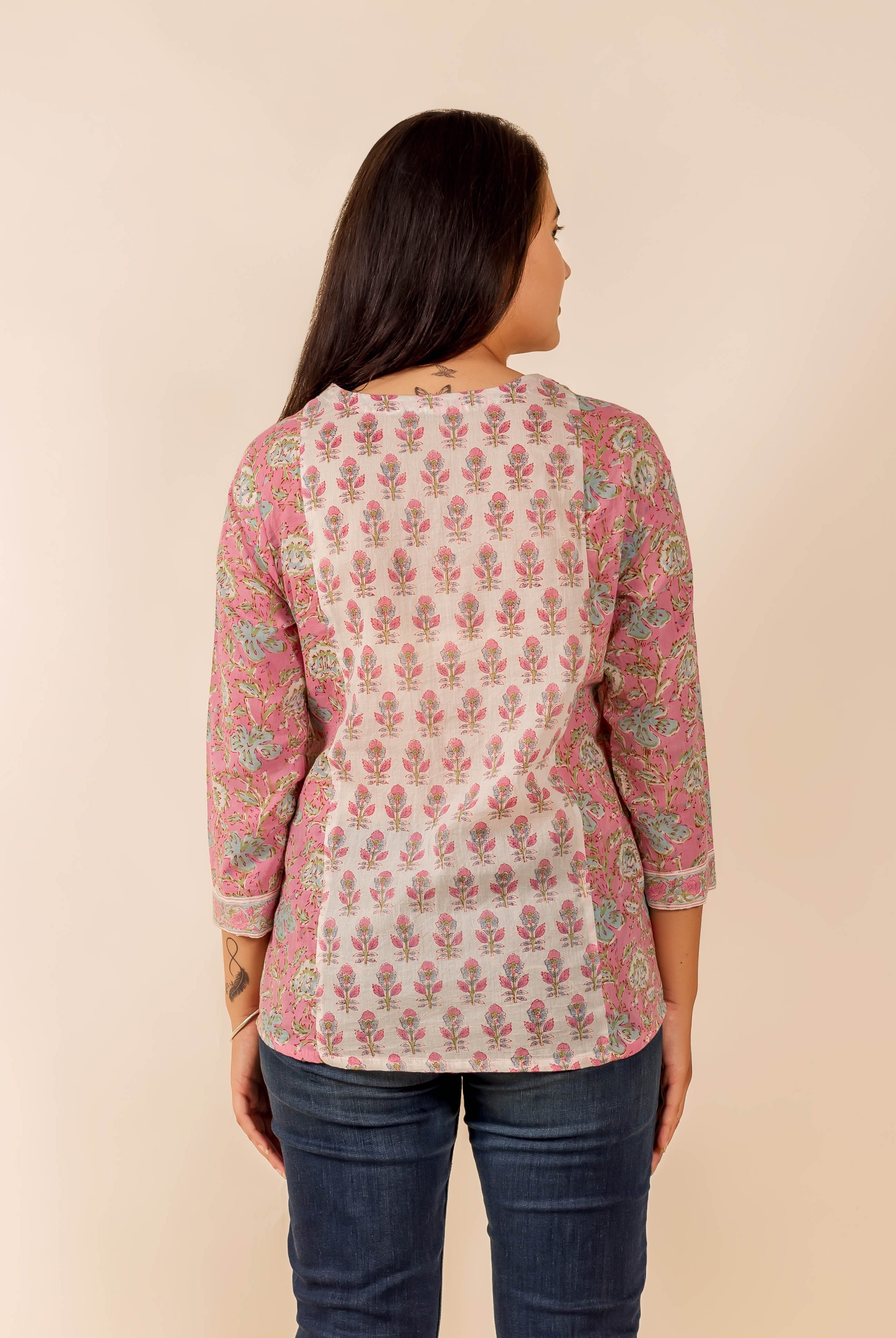 Back view of model in pink and white hand-block printed floral top.
