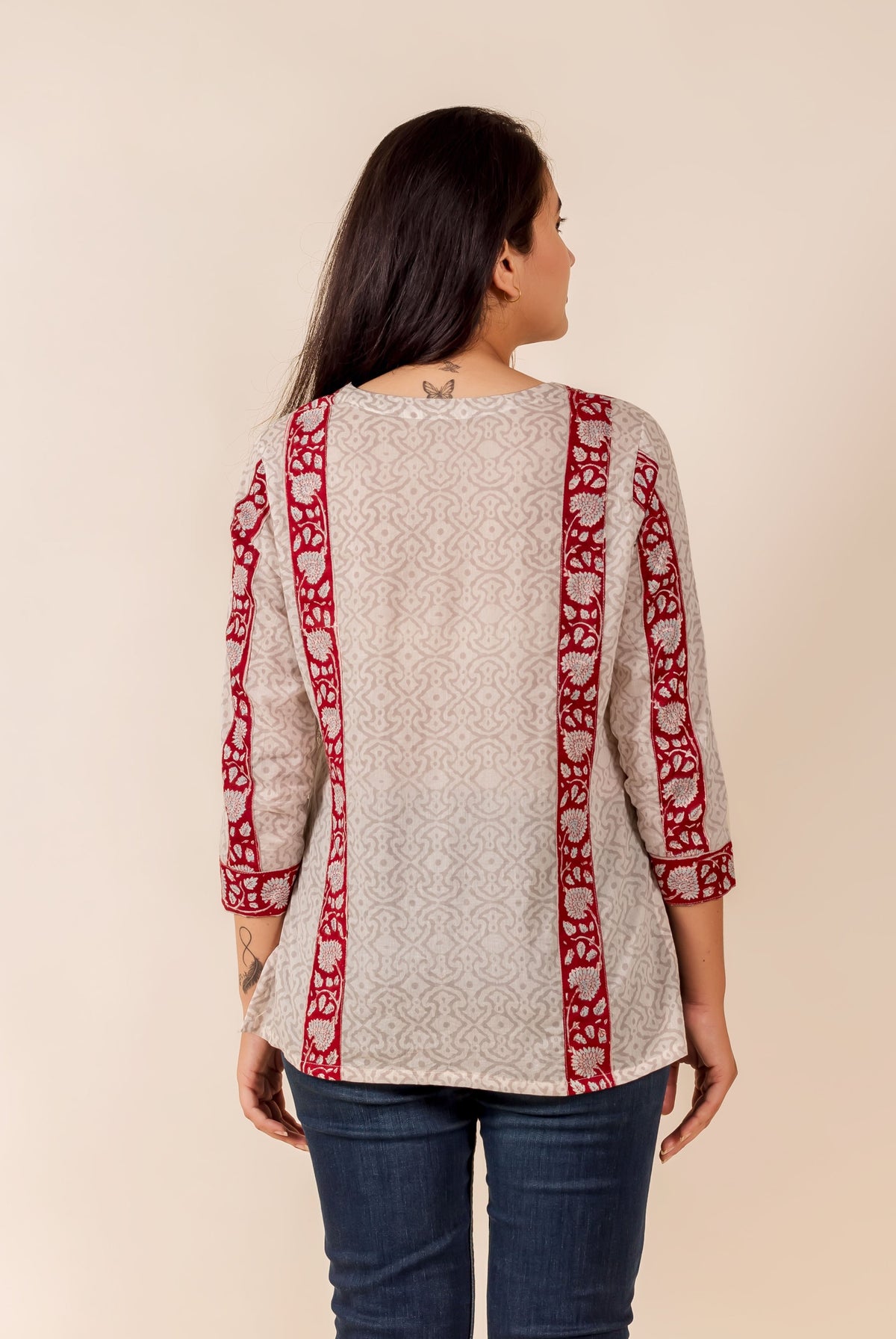 Back view: Off-white top with subtle print and prominent maroon patterned borders.