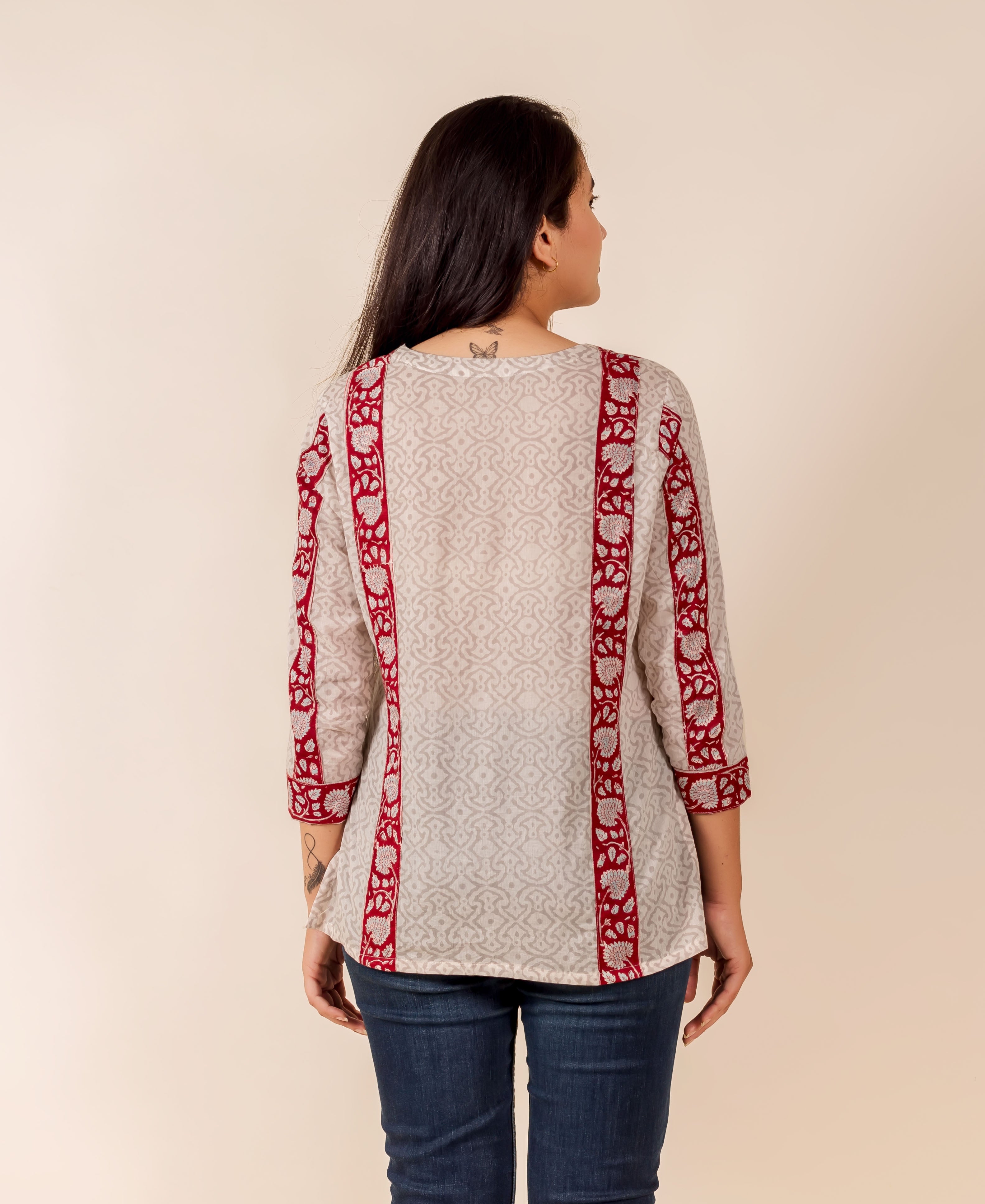 Back view: Off-white top with subtle print and prominent maroon patterned borders.