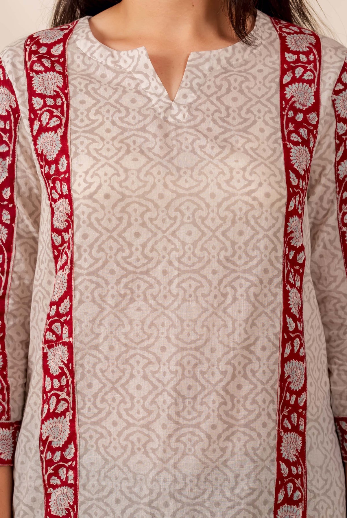 Person wearing off-white geometric hand-block printed top with maroon floral borders.