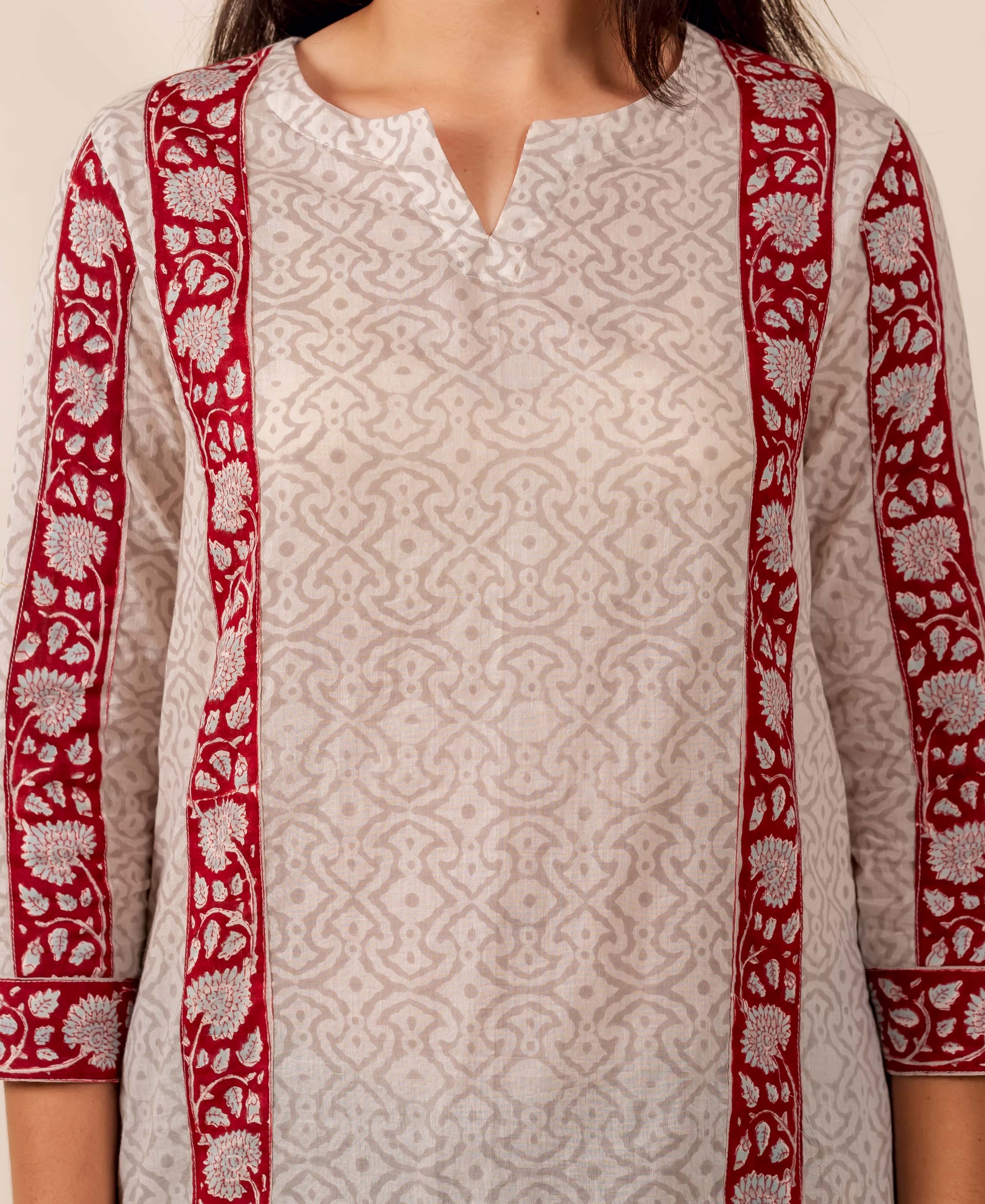 Person wearing off-white geometric hand-block printed top with maroon floral borders.