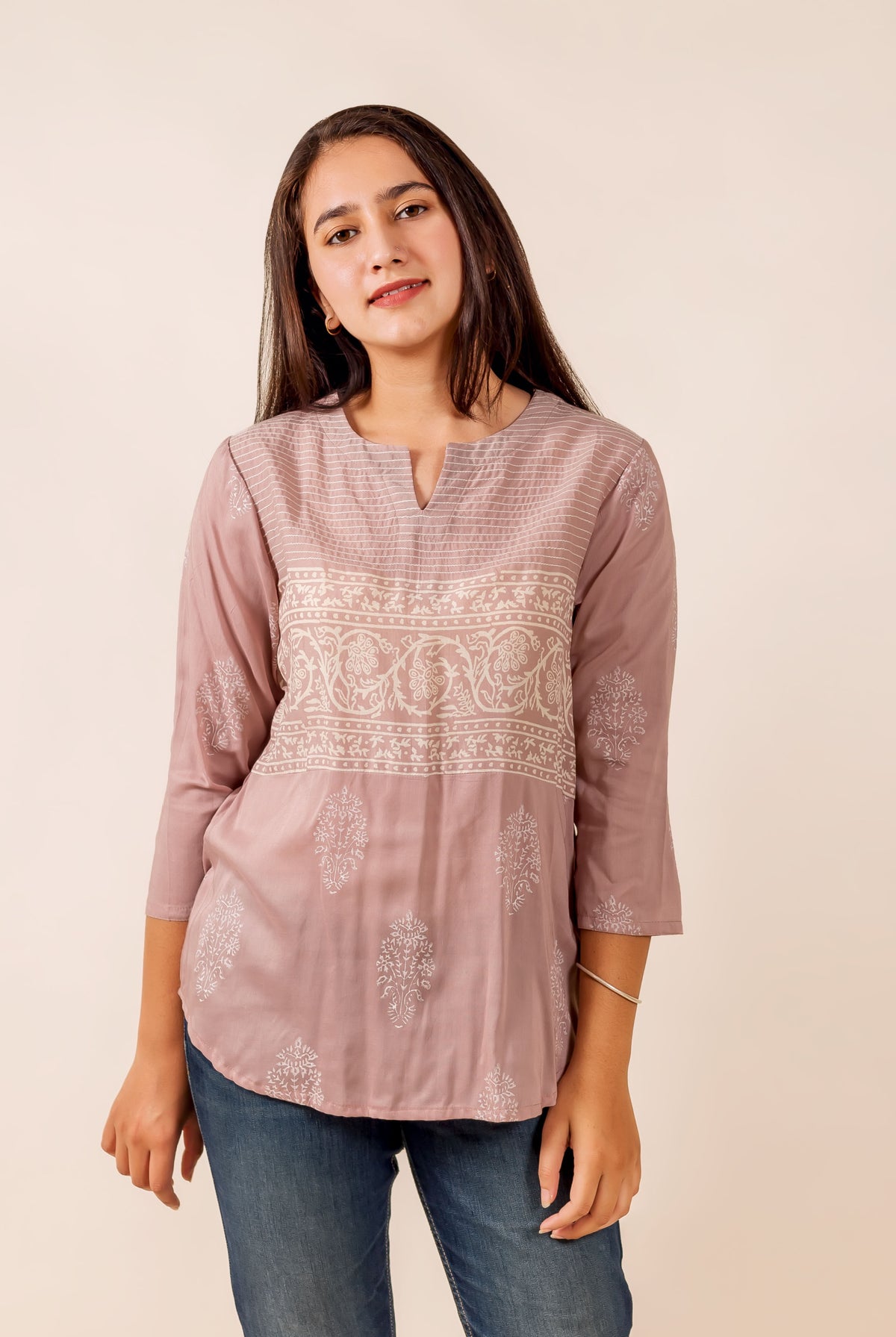 Model in a dusty pink ethnic top with white hand-block print, floral design, and thread work.