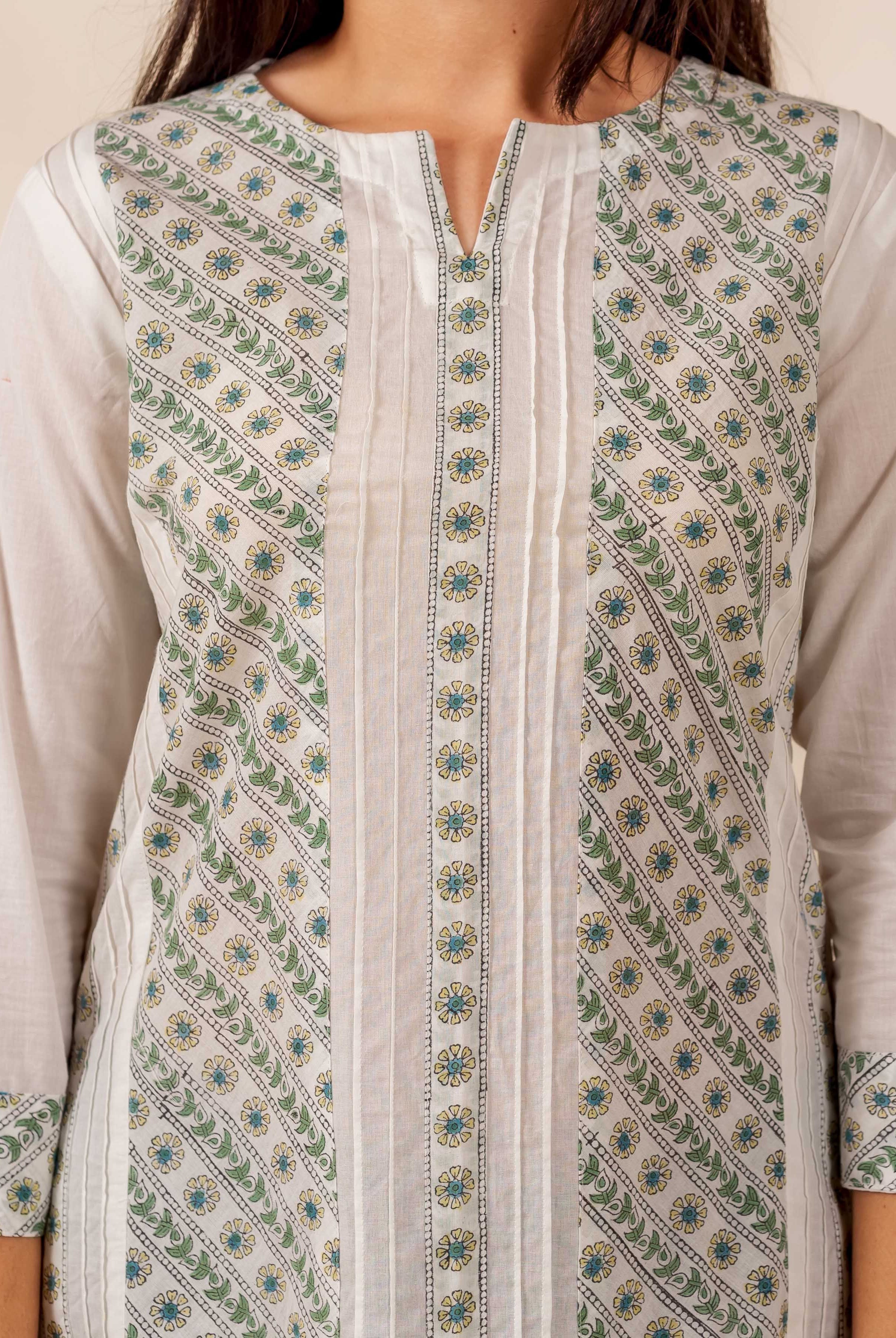 Close-up of model wearing white and green hand-block printed pintuck top with floral motifs.