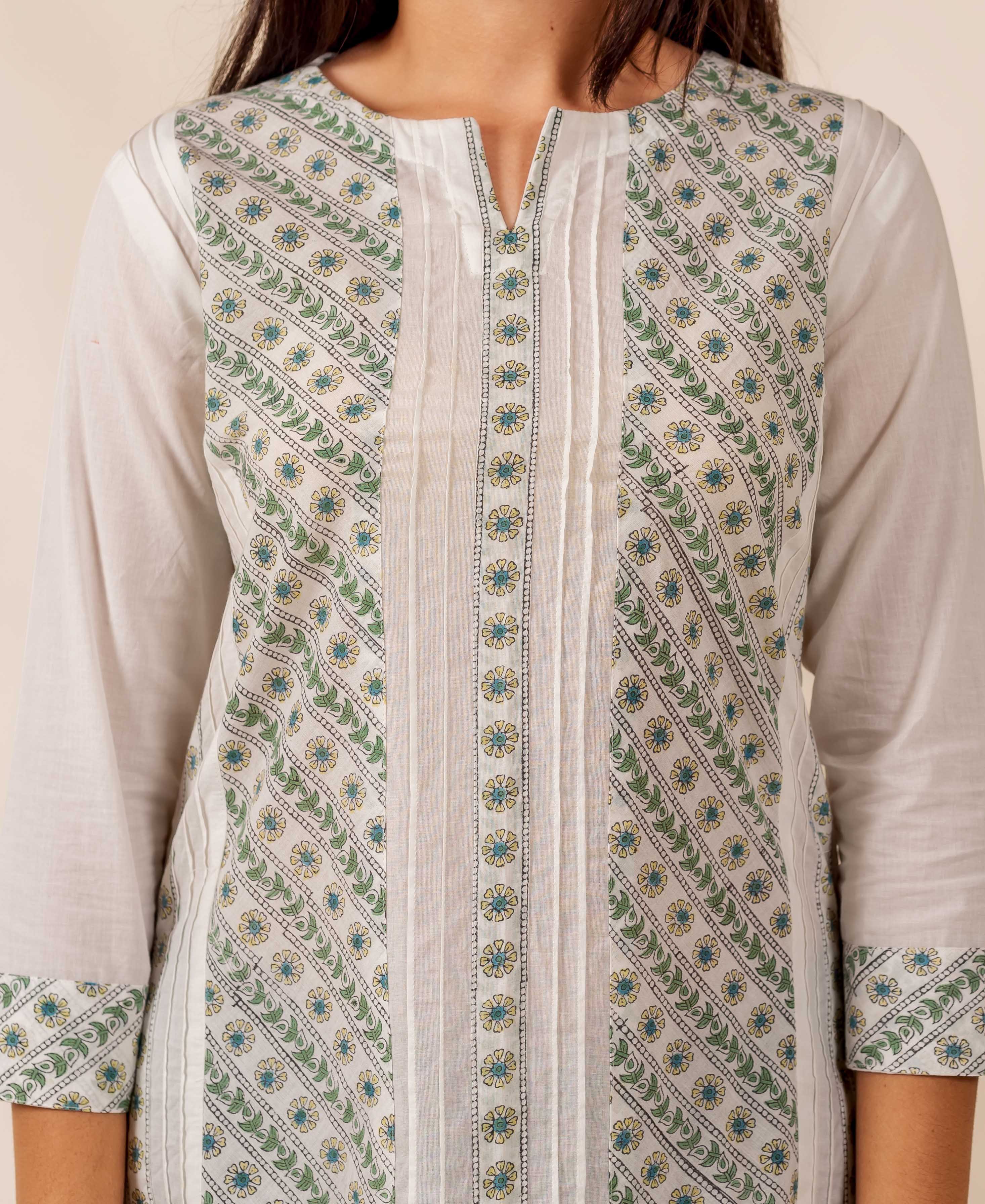 Close-up of model wearing white and green hand-block printed pintuck top with floral motifs.