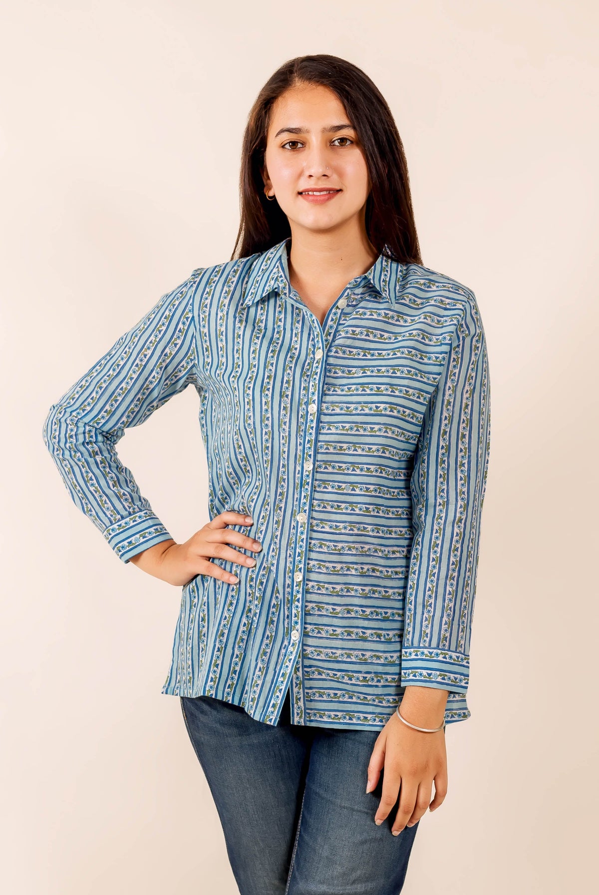 Smiling model in blue hand block printed button-down shirt and jeans, showing striped pattern.