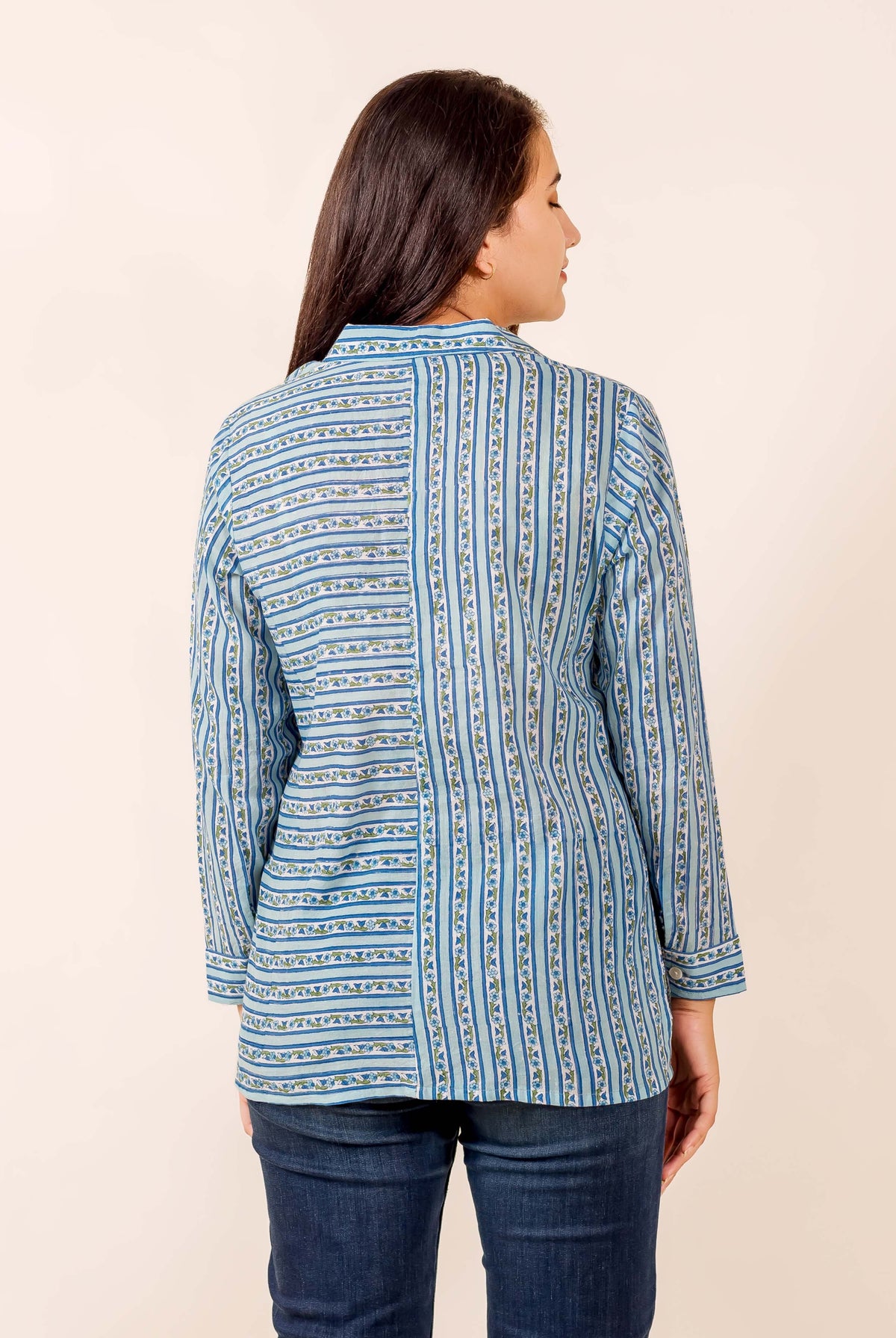 Model's back, blue hand-block printed button-down shirt with mixed horizontal and vertical stripes.