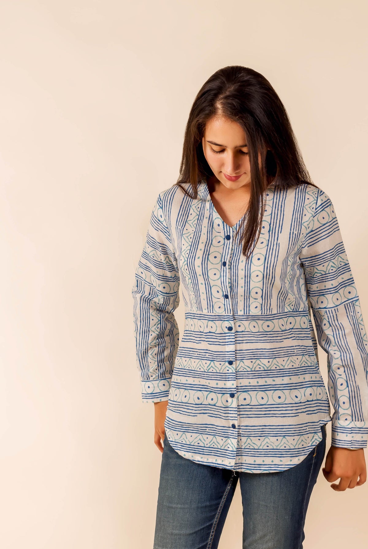 Model in a white and blue hand-block-printed ethnic long-sleeved shirt with varied patterns.