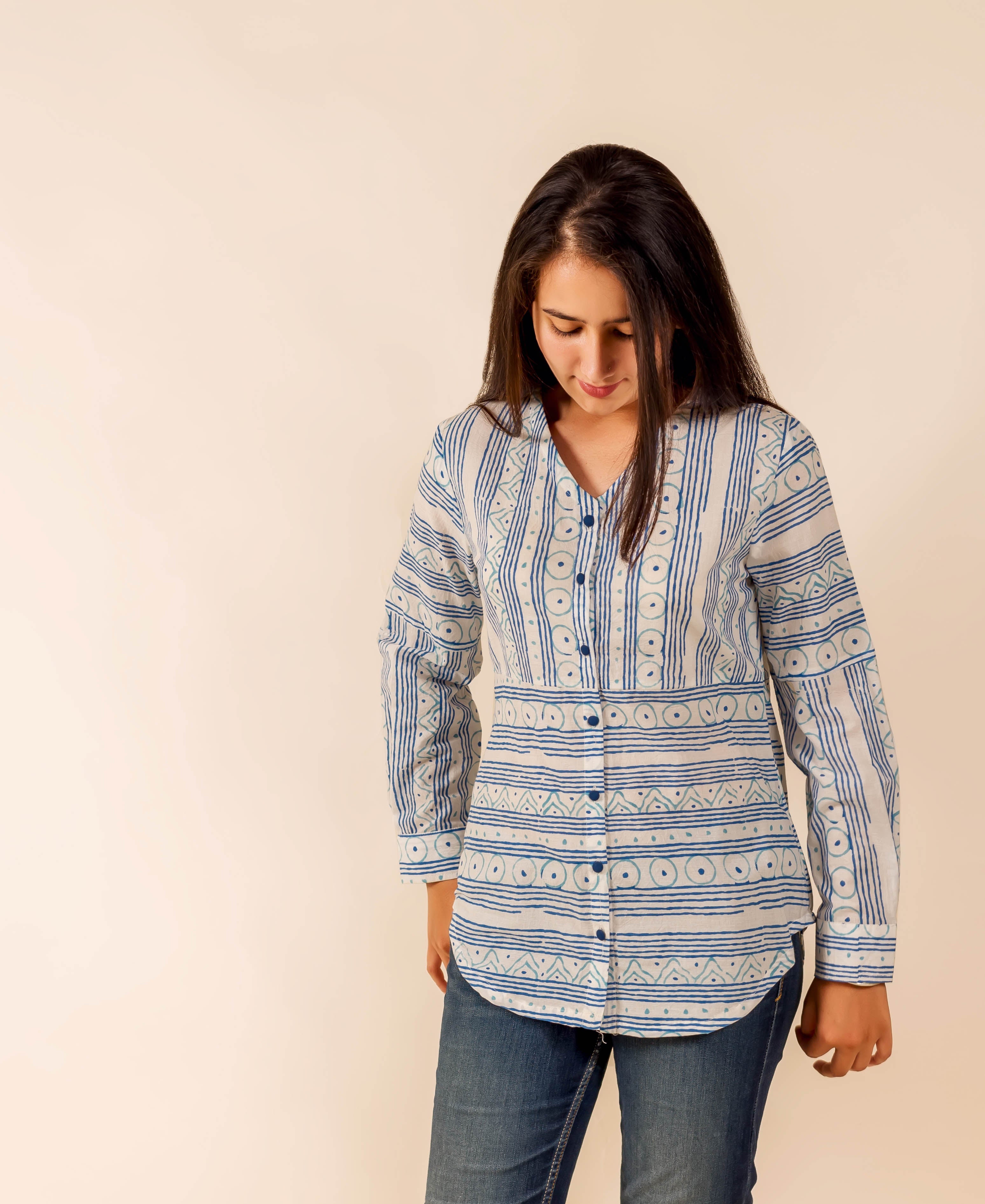 Model in a white and blue hand-block-printed ethnic long-sleeved shirt with varied patterns.
