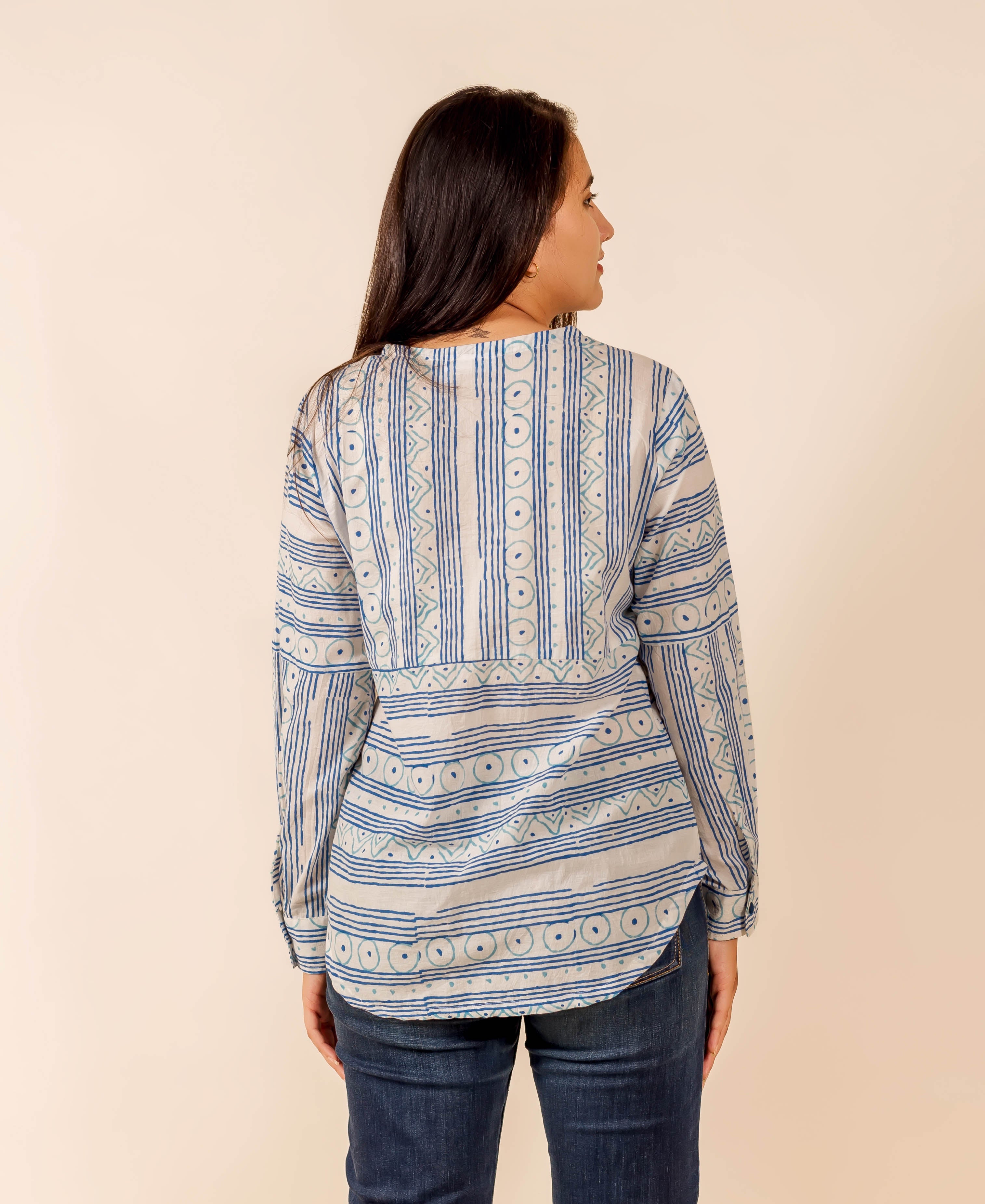 Rear view of model in white and blue ethnic block-printed long-sleeve shirt top.