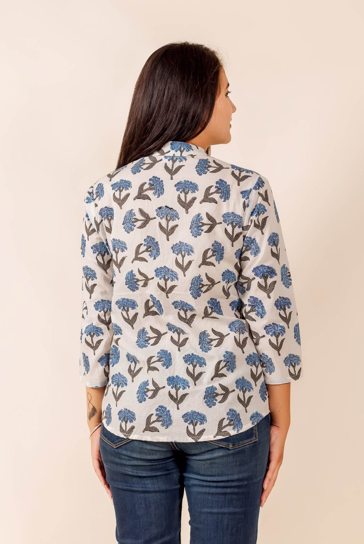 Rear view of model in a white top with blue floral hand-block print.