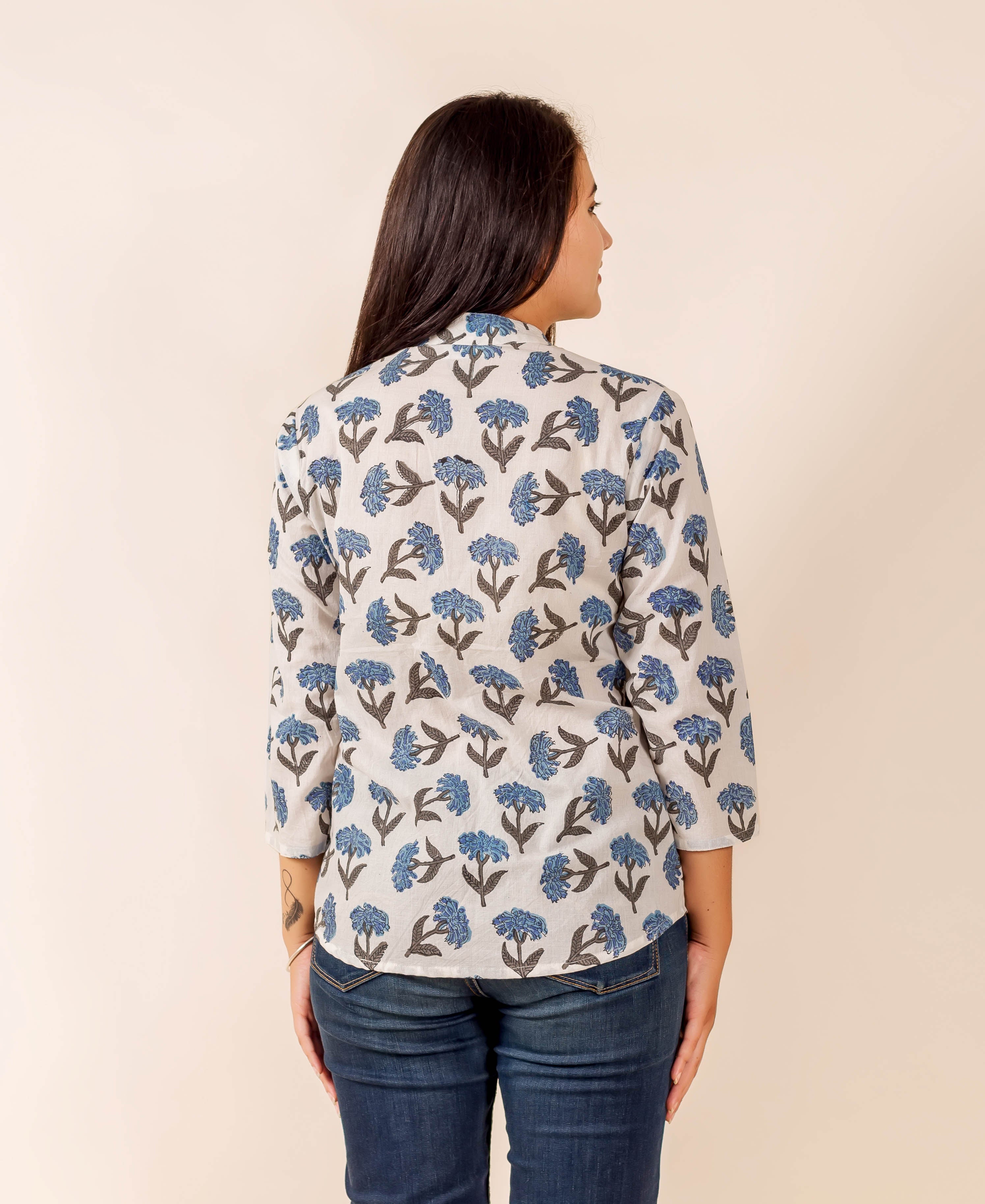 Rear view of model in a white top with blue floral hand-block print.
