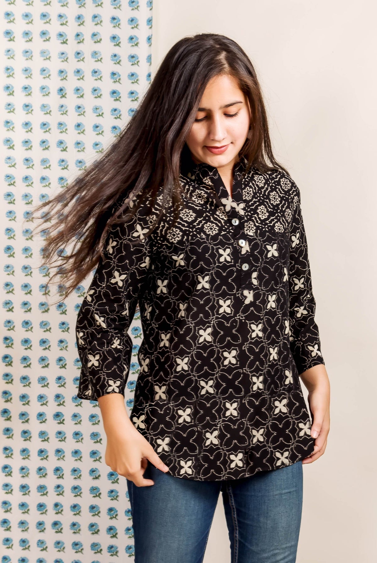 Front view model in ethnic black hand block printed top with white geometric pattern.
