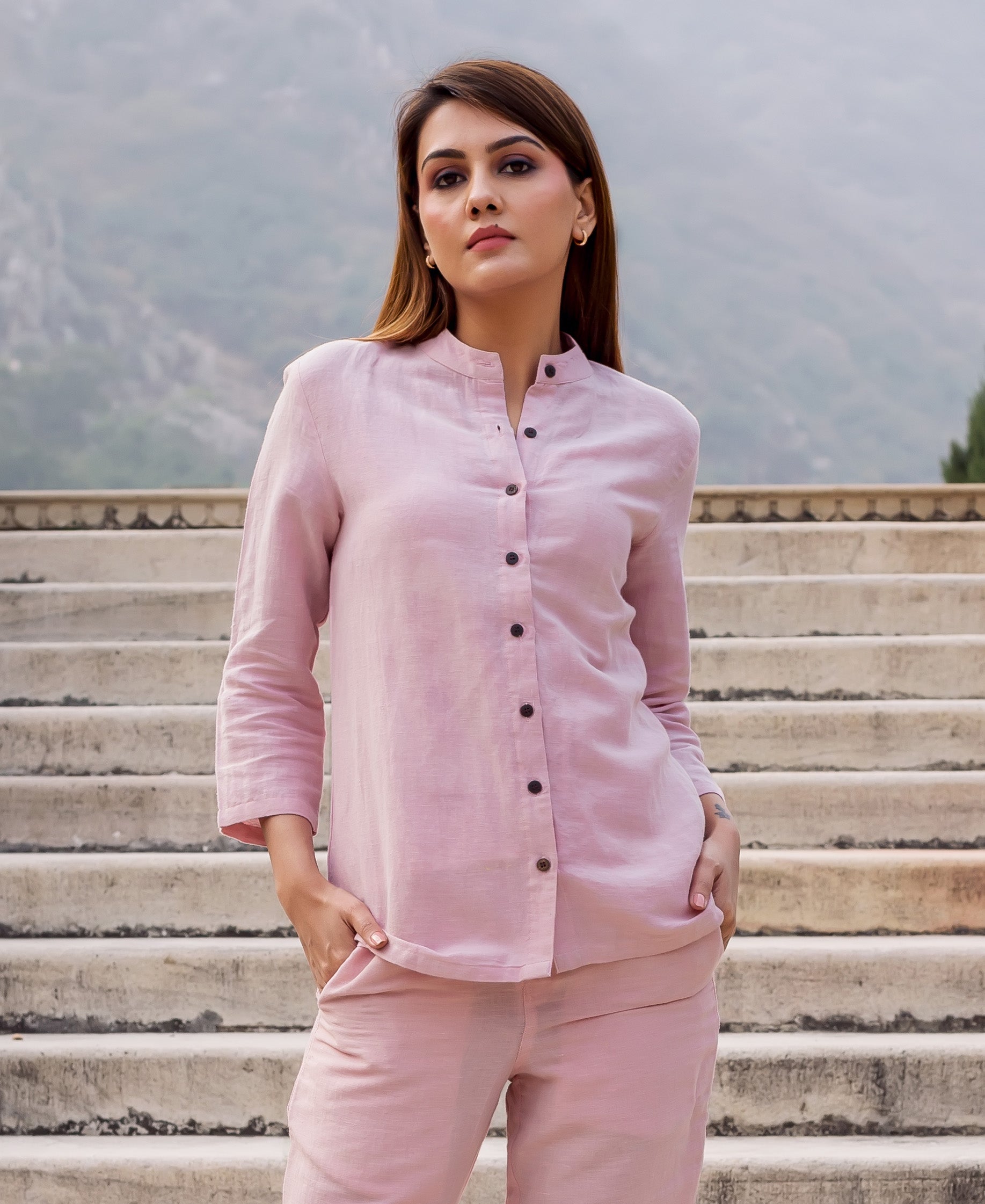 Front view of model in solid flamingo pink linen collared top and matching pants.