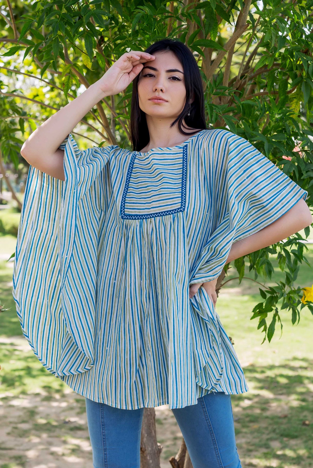 Front view model in blue and green striped block printed kaftan top and jeans.
