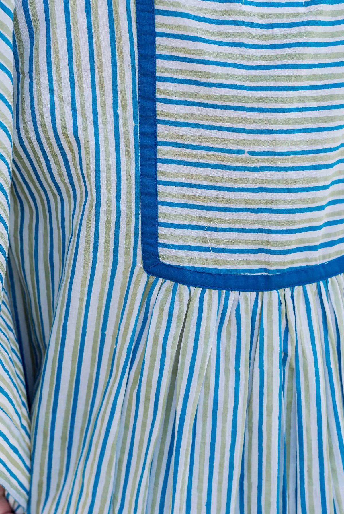 Front close-up of blue and green striped block-printed kaftan top with square yoke.