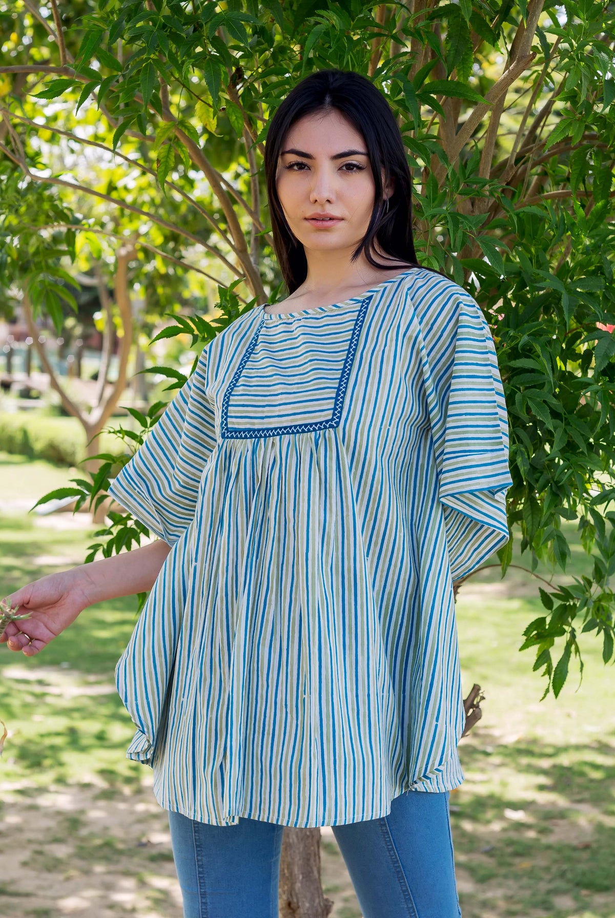 Front view of model wearing blue and light green vertical striped block printed kaftan top.