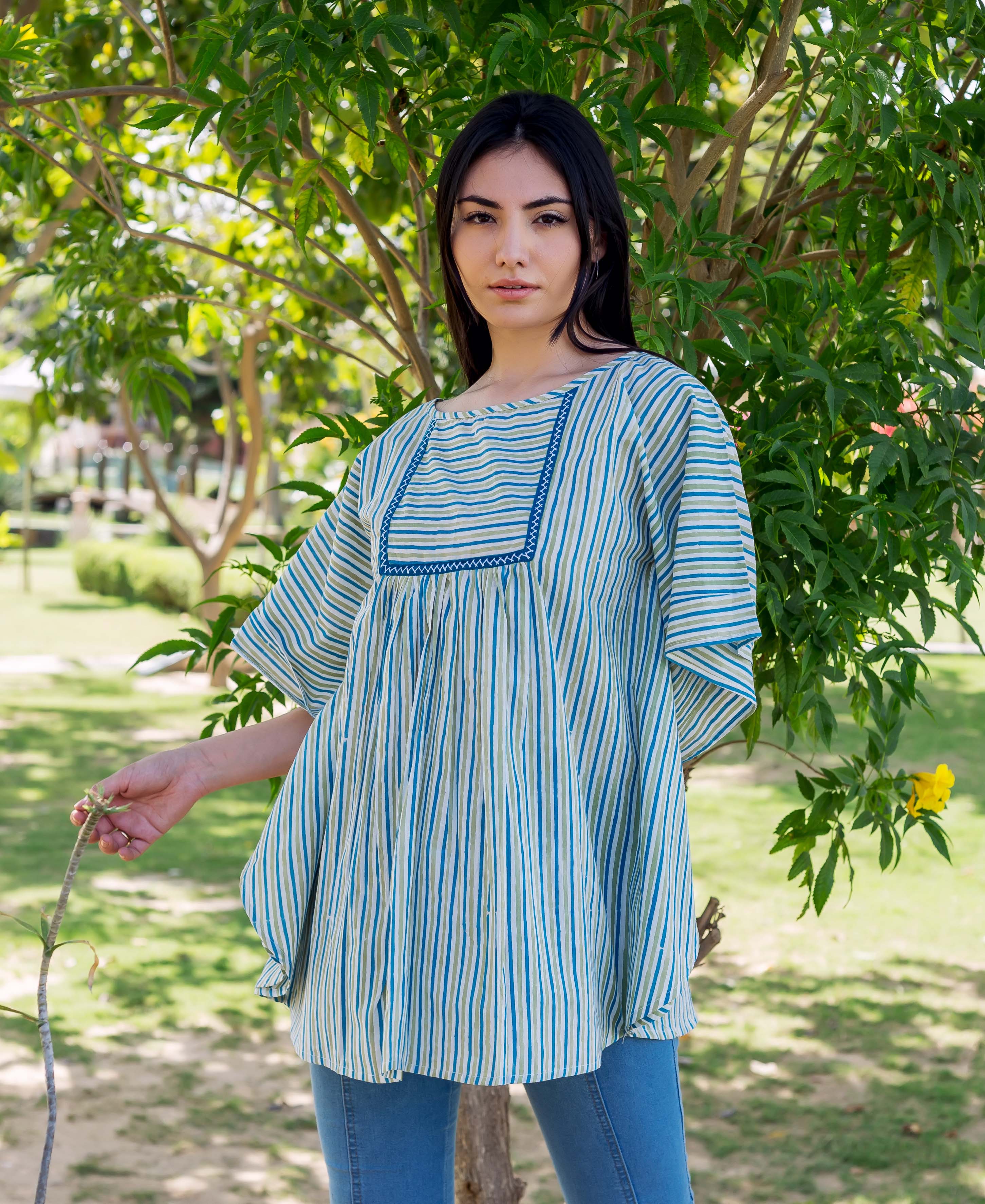 Front view of model wearing blue and light green vertical striped block printed kaftan top.
