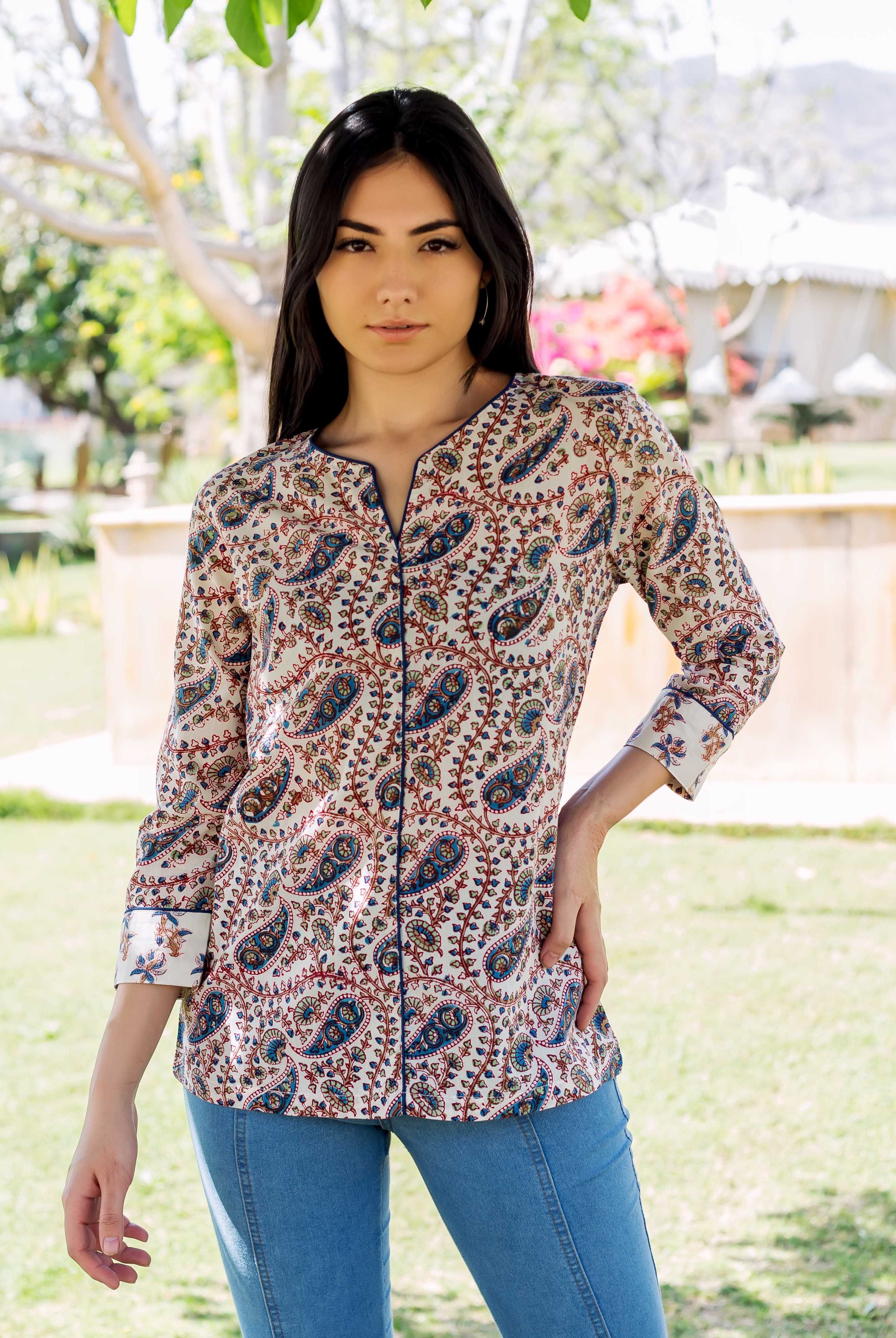 Model wearing white hand-block printed ethnic top with blue and red paisley pattern, front view.