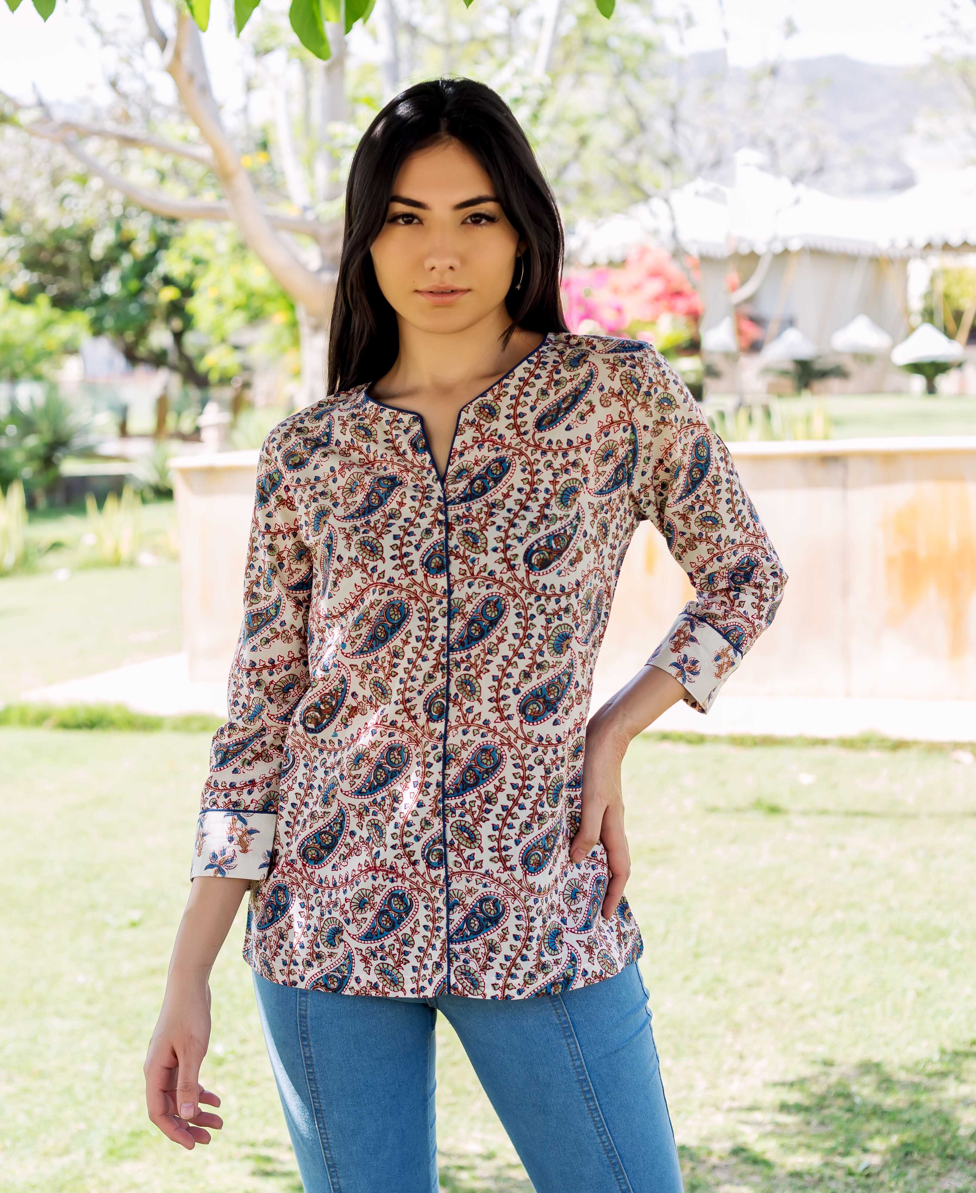 Model wearing white hand-block printed ethnic top with blue and red paisley pattern, front view.
