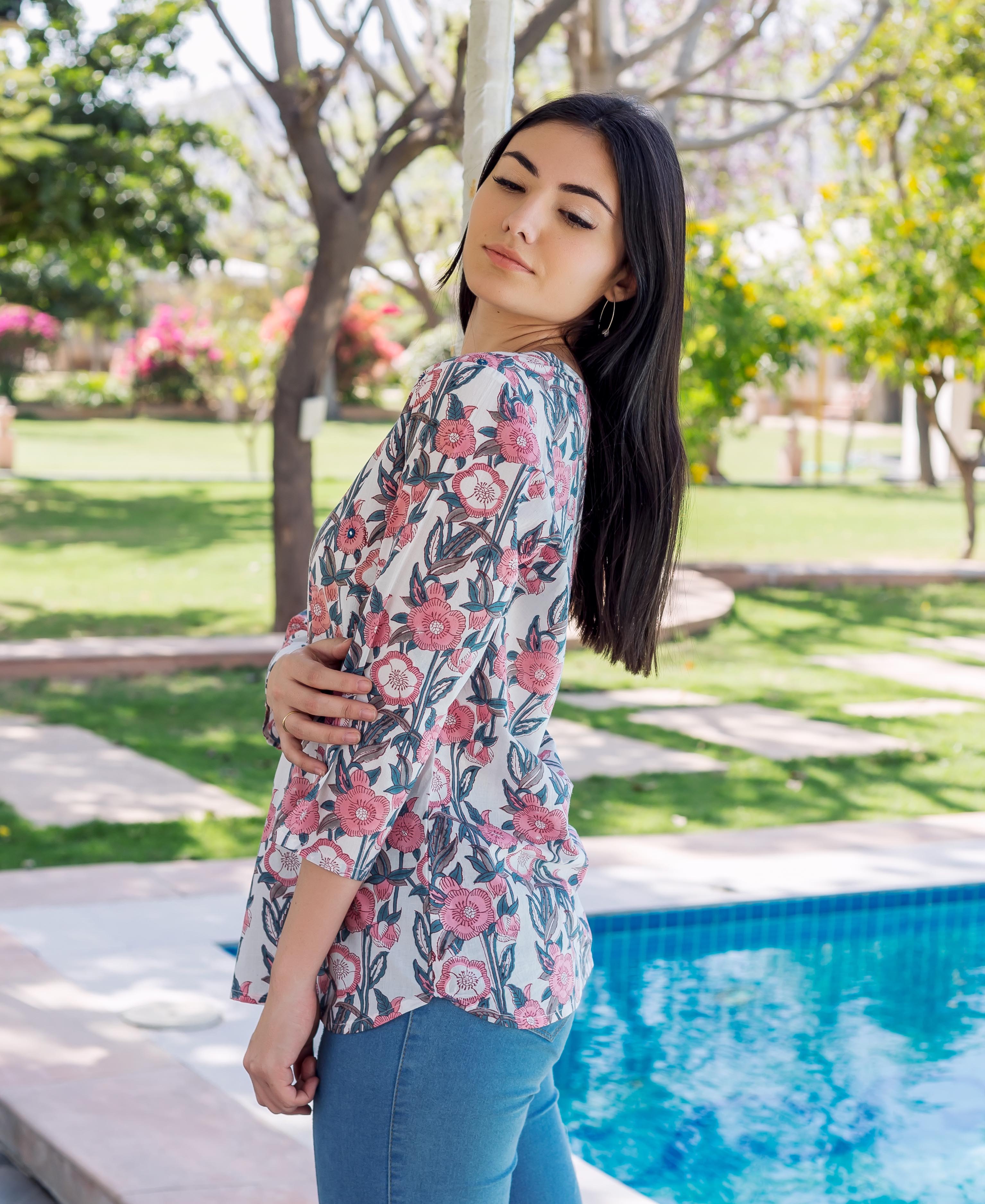 Side view of model wearing a grey and pink block printed Noya top.