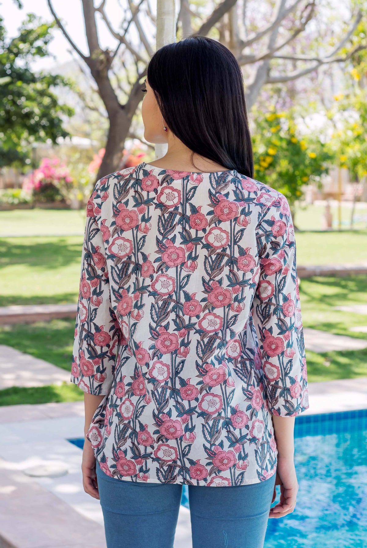 Grey and pink block printed Noya Top on a model, back view.