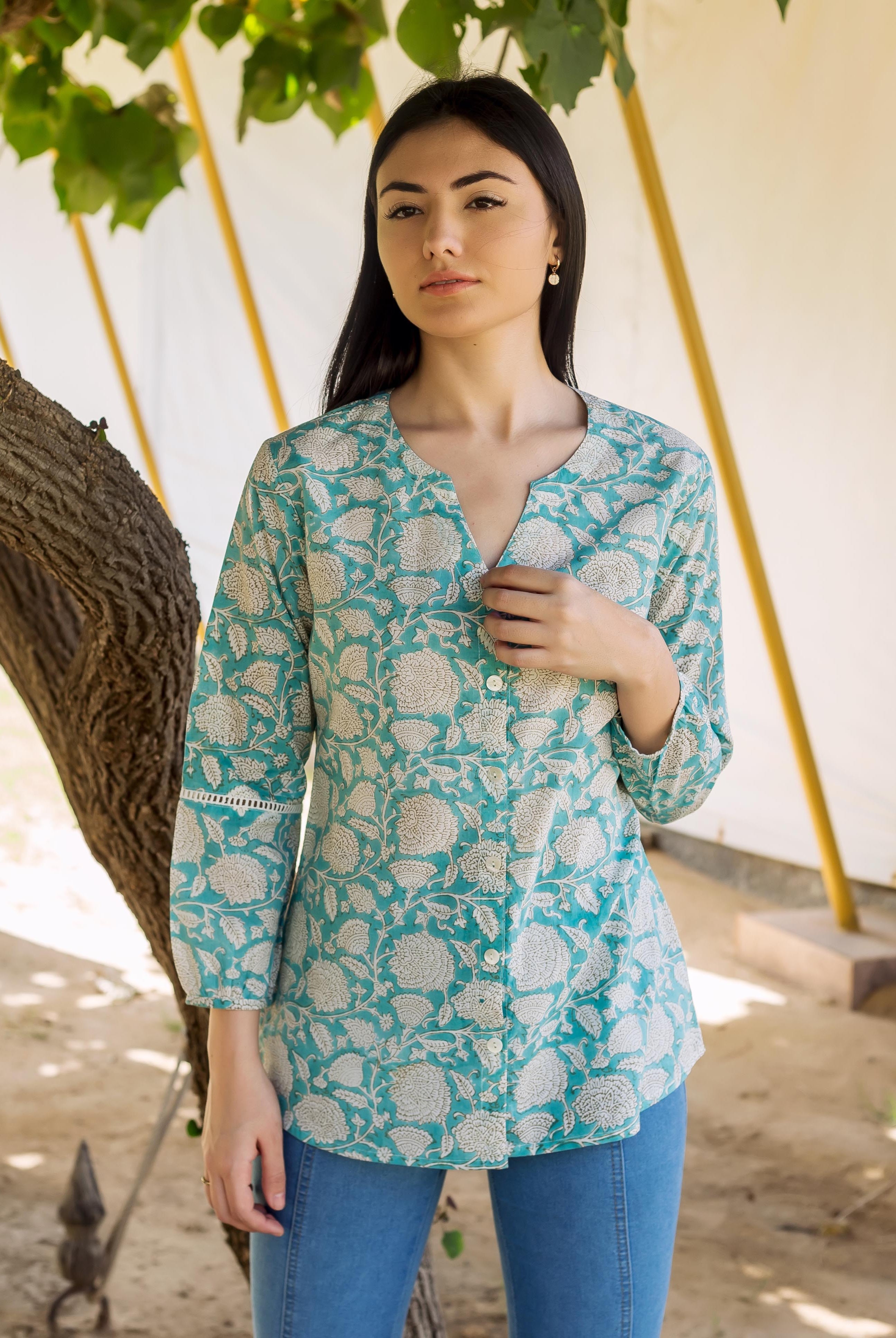 A woman wearing a blue and white floral print top with lace detailing.