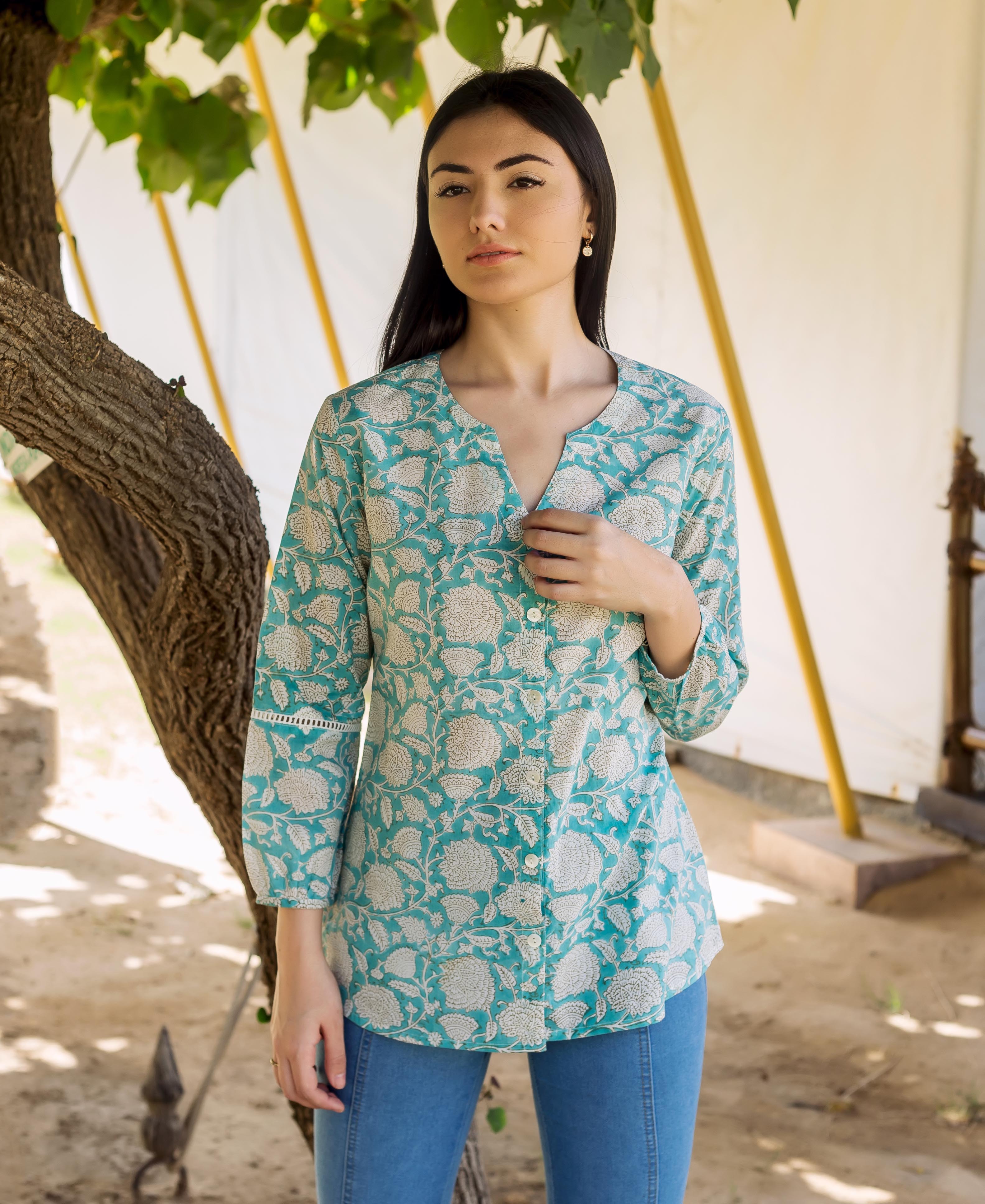 A woman wearing a blue and white floral print top with lace detailing.