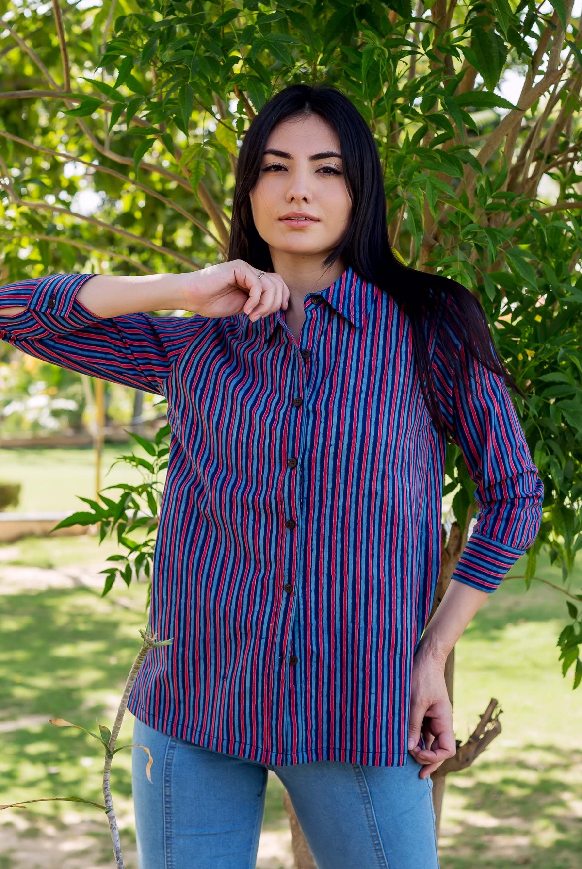 Front-facing model wearing an Indigo and Red striped Kiara shirt with light blue jeans.