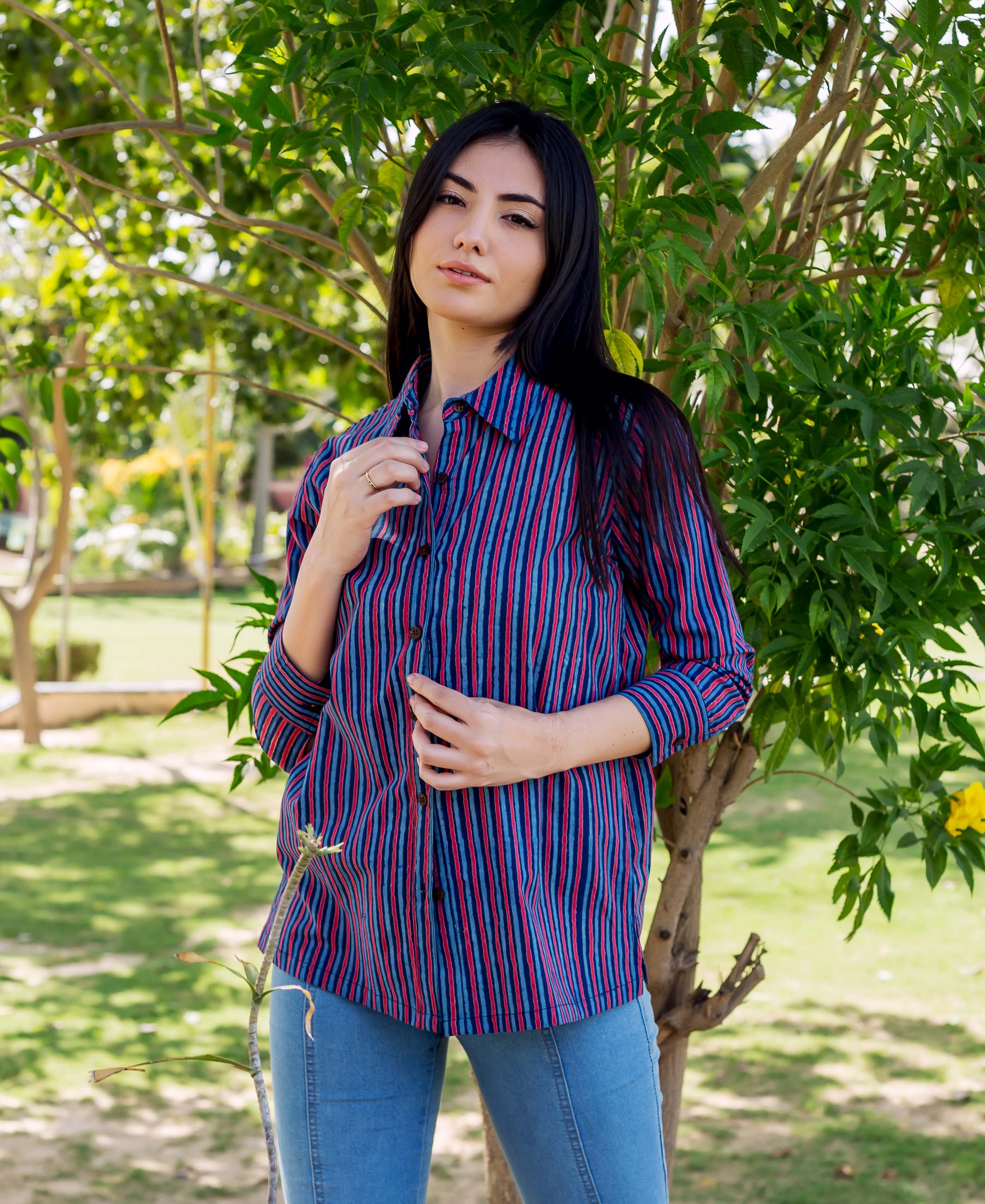 A model wearing a blue and red striped shirt with a collar and buttons.