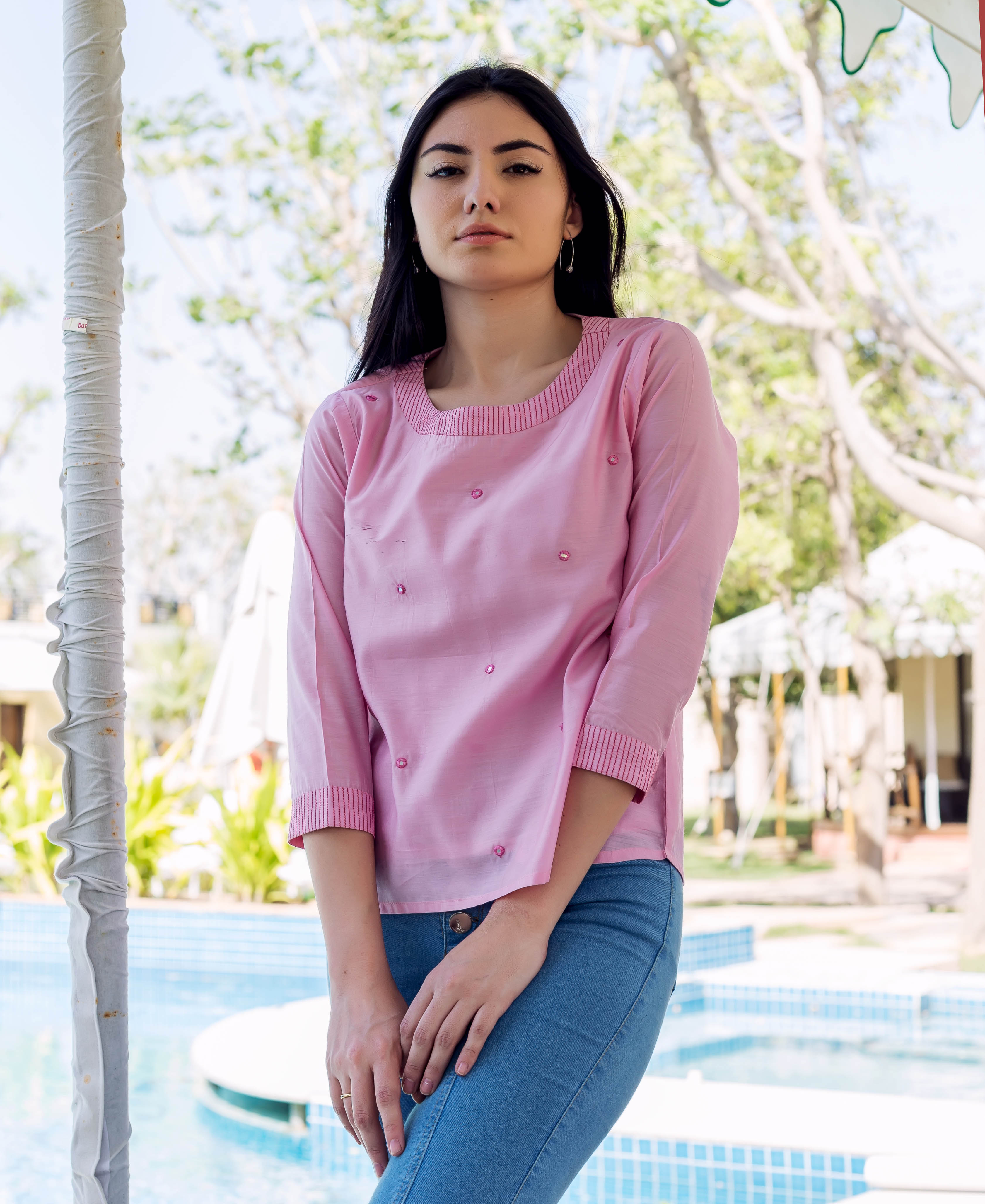 Pink chanderi embroidered top on model with embellishments and striped neck and cuffs.