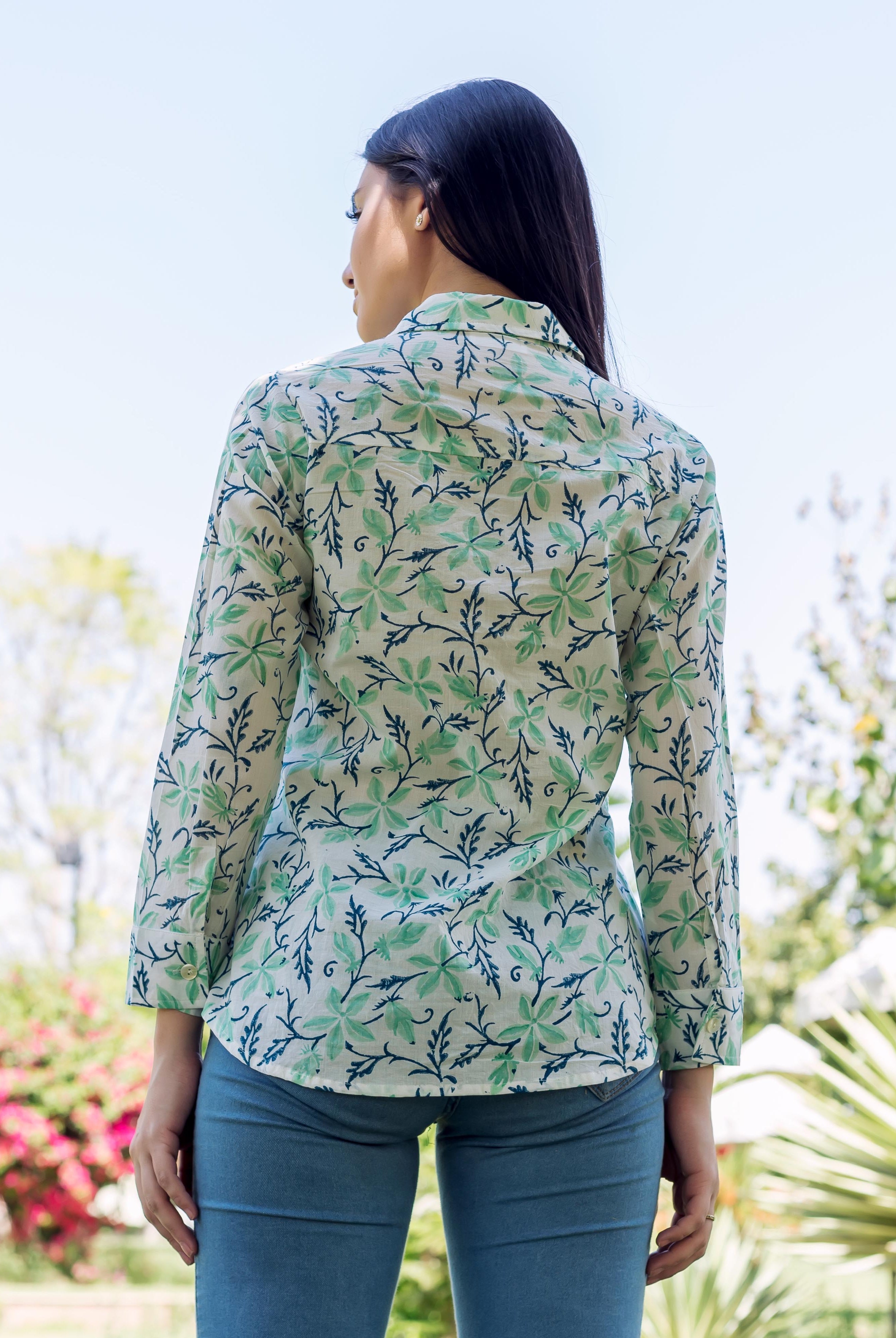 Back view of model in white, sea green, and blue floral block-printed shirt.
