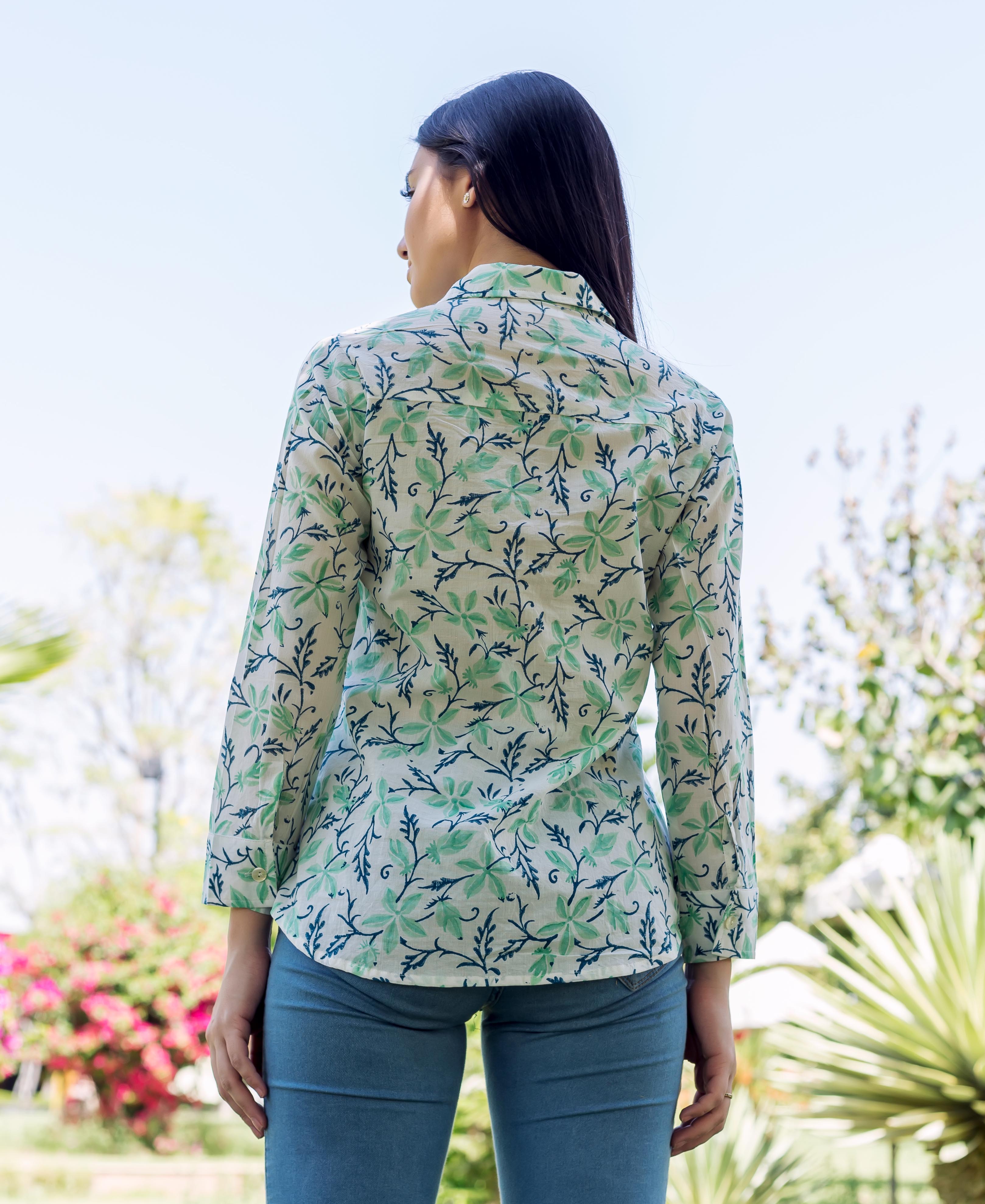 Back view of model in white, sea green, and blue floral block-printed shirt.