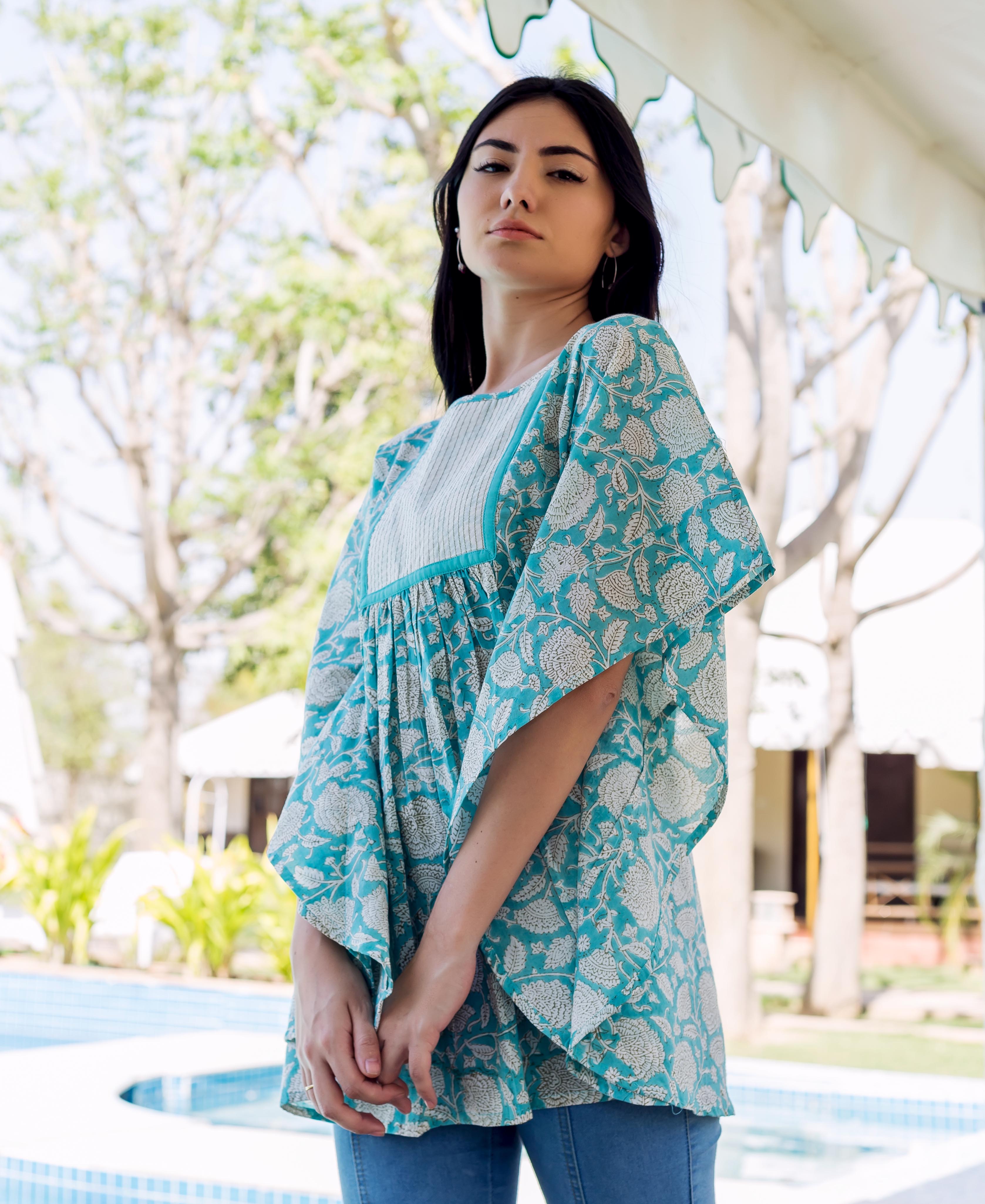 Model wearing a flowing sea blue kaftan top with white hand-block-printed floral patterns.