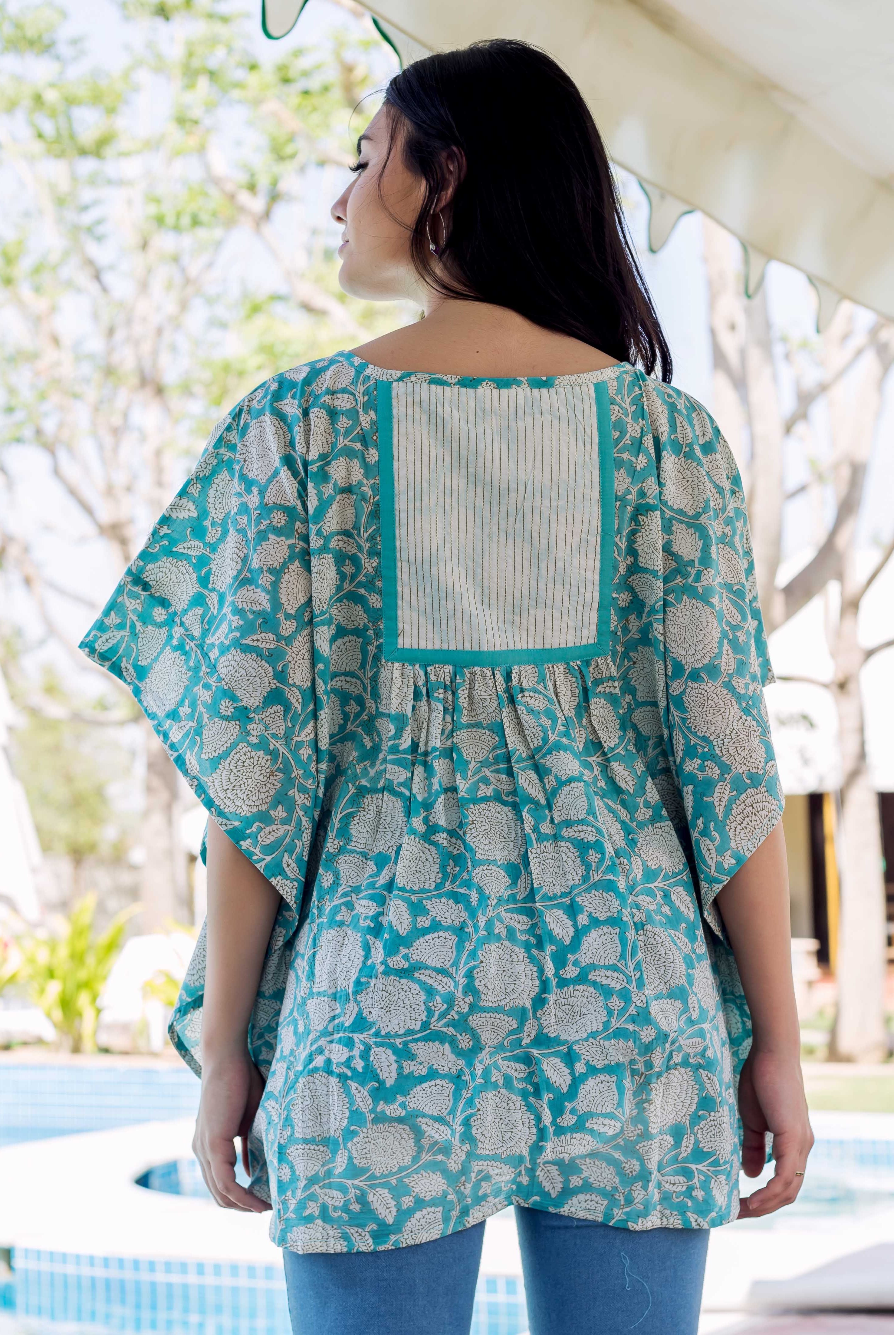 Back view: model in a sea blue kaftan top with ethnic hand-block floral print.