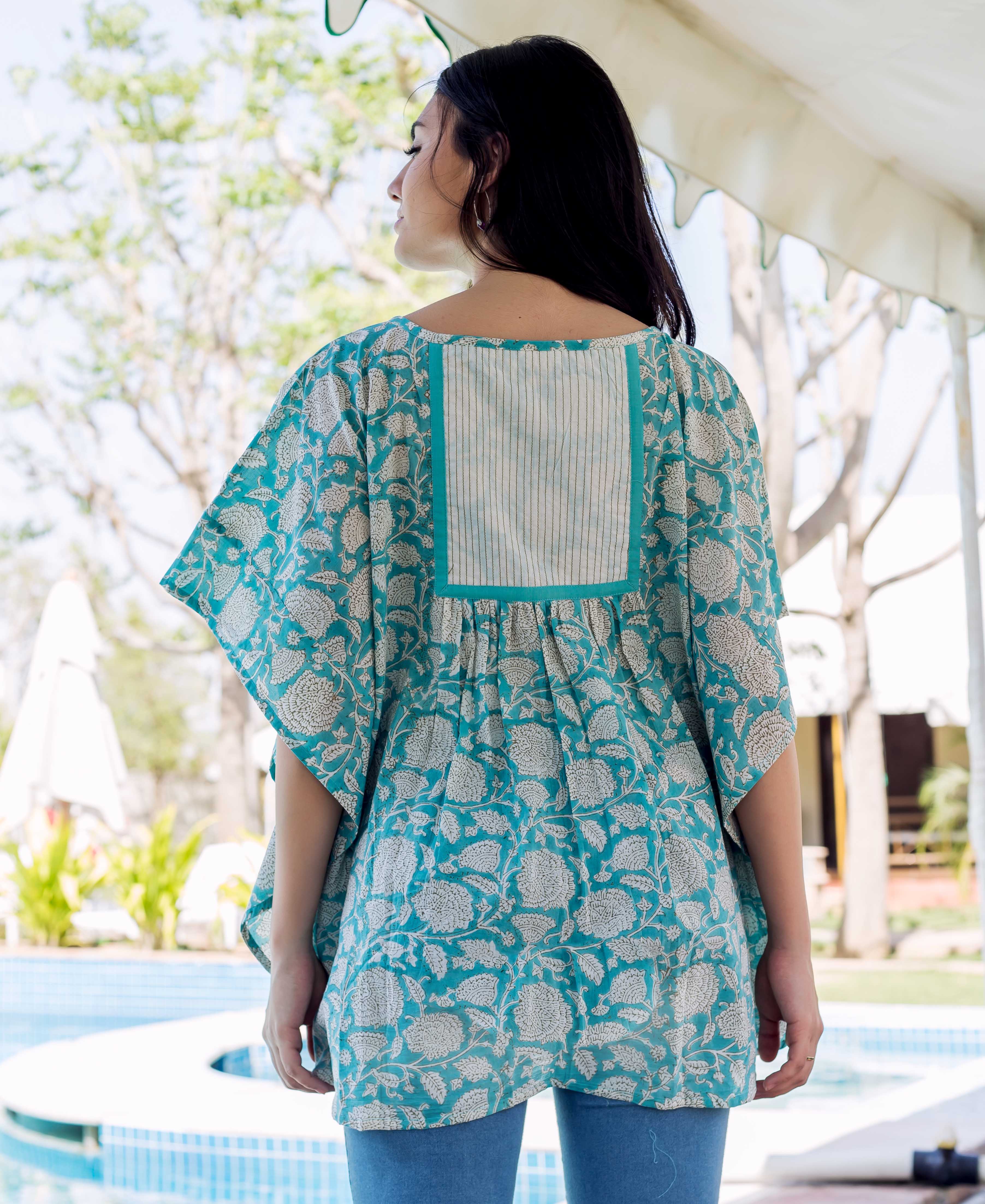 Back view: model in a sea blue kaftan top with ethnic hand-block floral print.