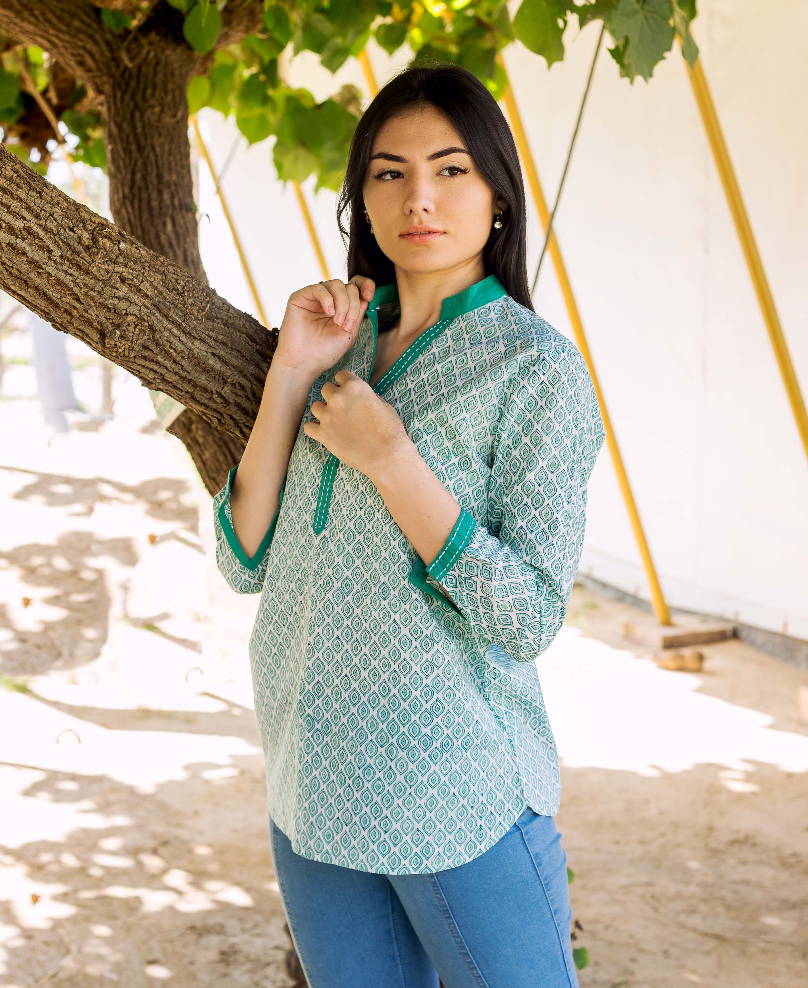Female model wears a green and white hand block printed tunic with geometric pattern.