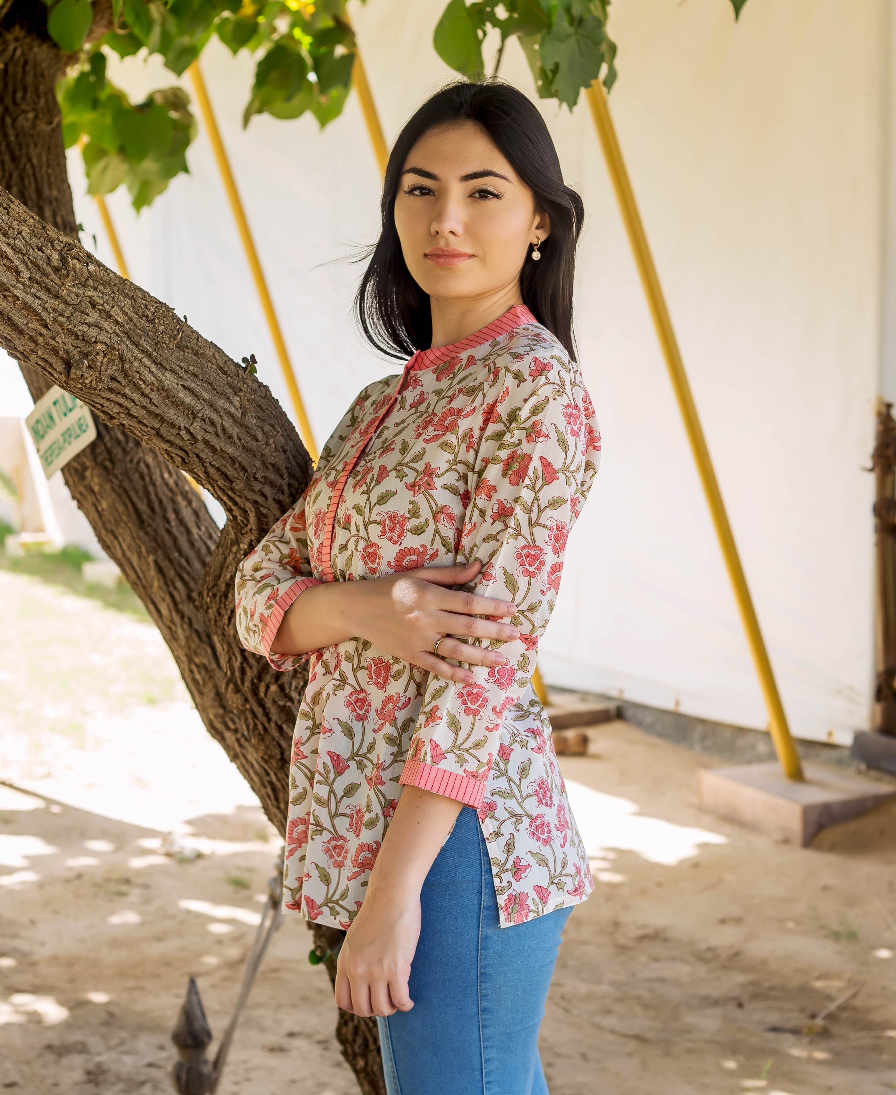 Woman wearing a white short-sleeved top with peach floral Jaal print.