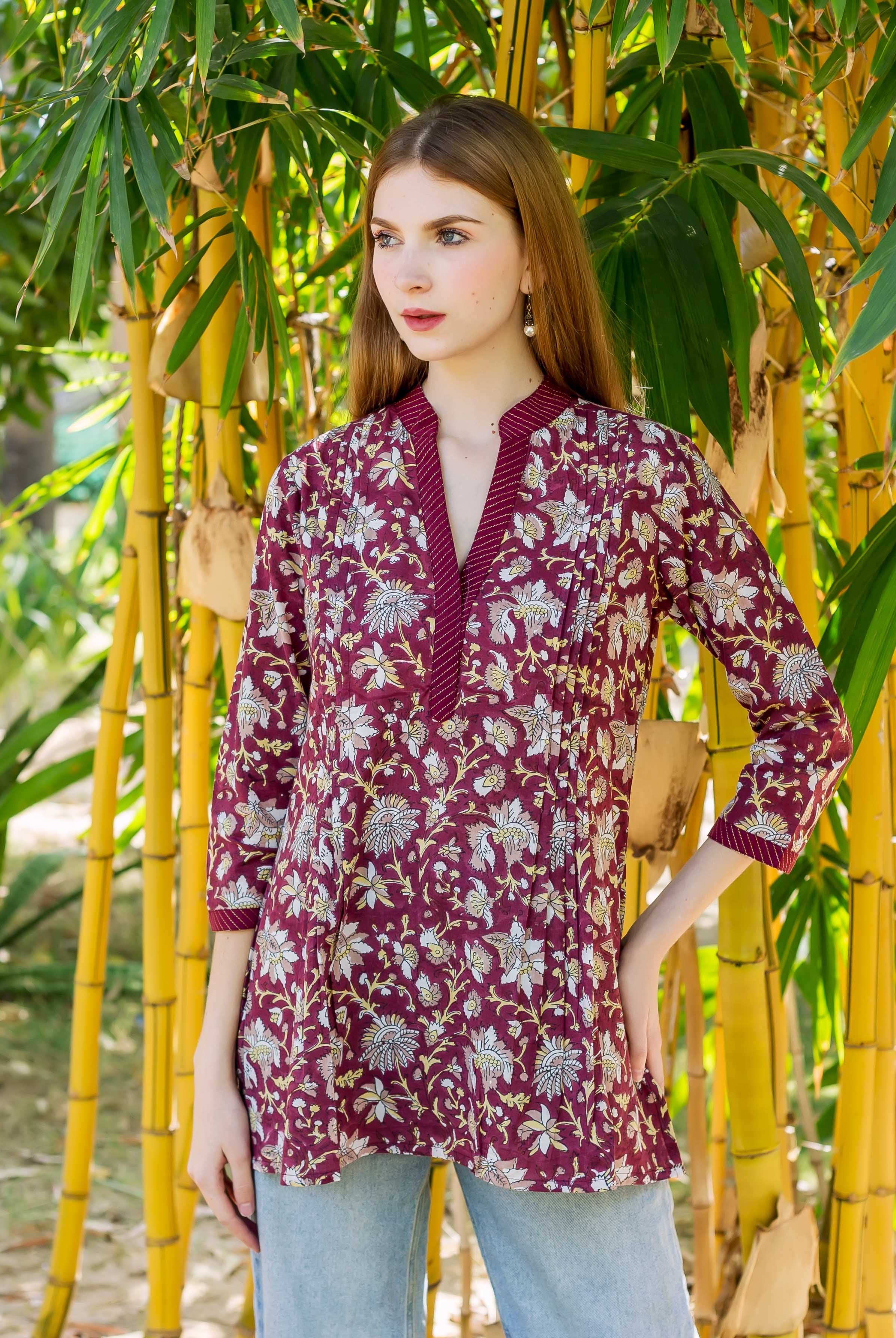 Model in a wine hand-block-printed floral tunic top with a V-neck.