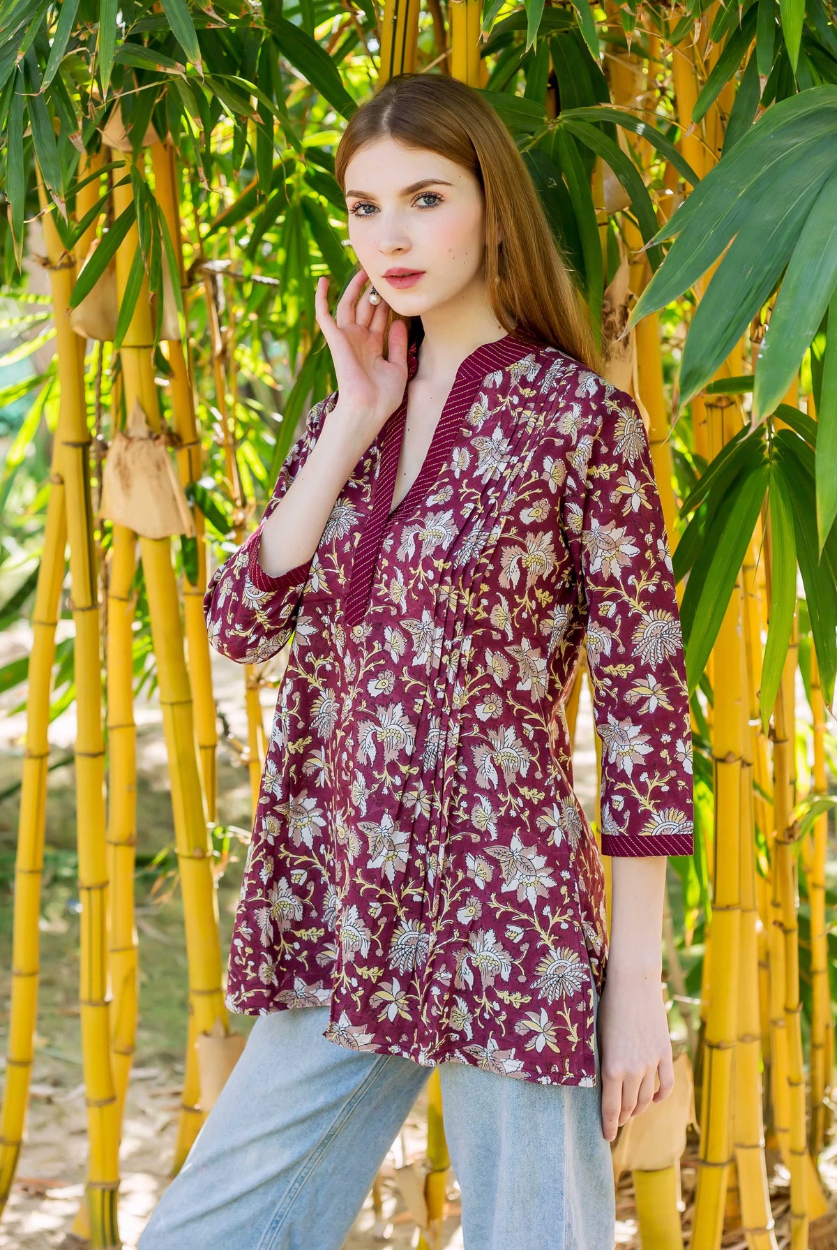 Model wearing a wine hand-block printed ethnic top with white and yellow floral patterns.