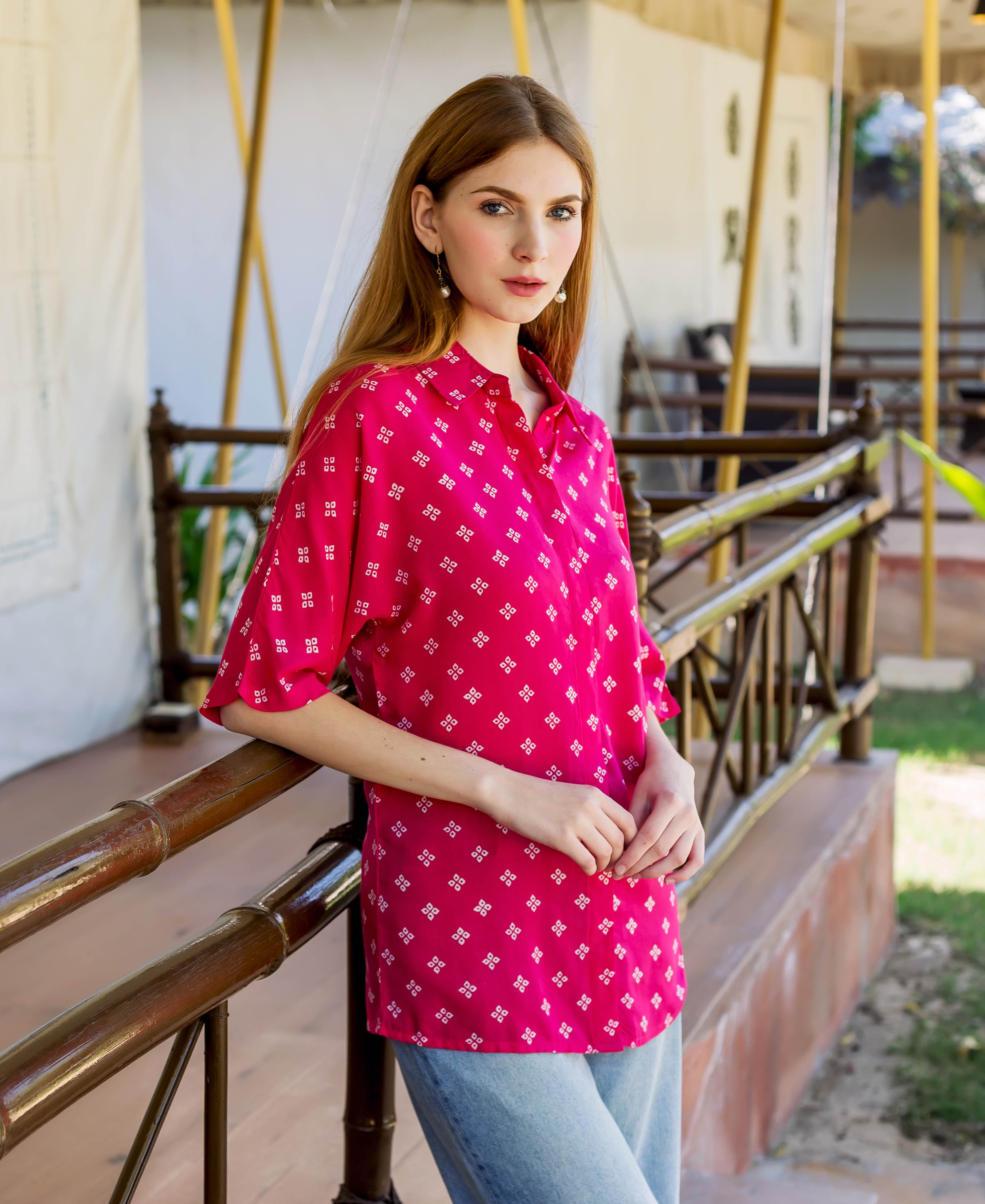 A model wearing a magenta bandhej printed button-down shirt with white geometric patterns.