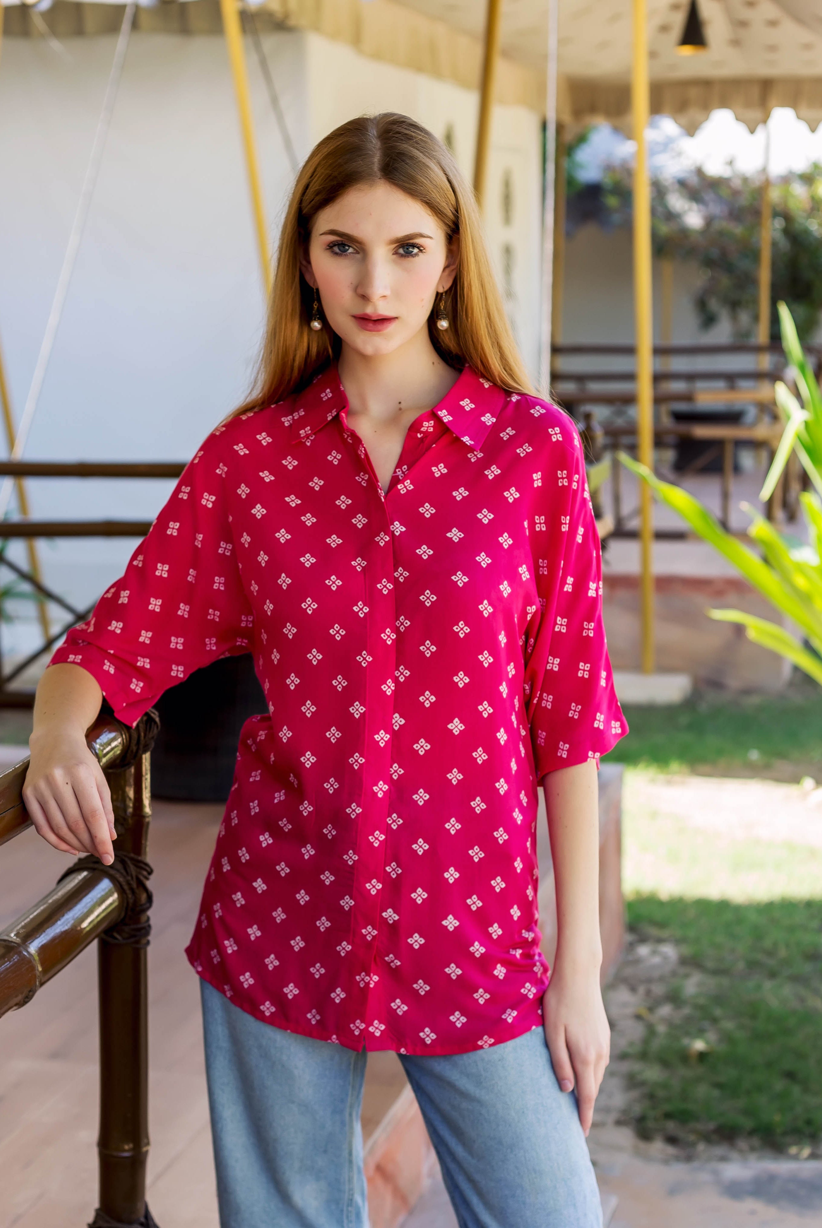Magenta Bandhej printed button-down shirt on a standing model with white geometric patterns.