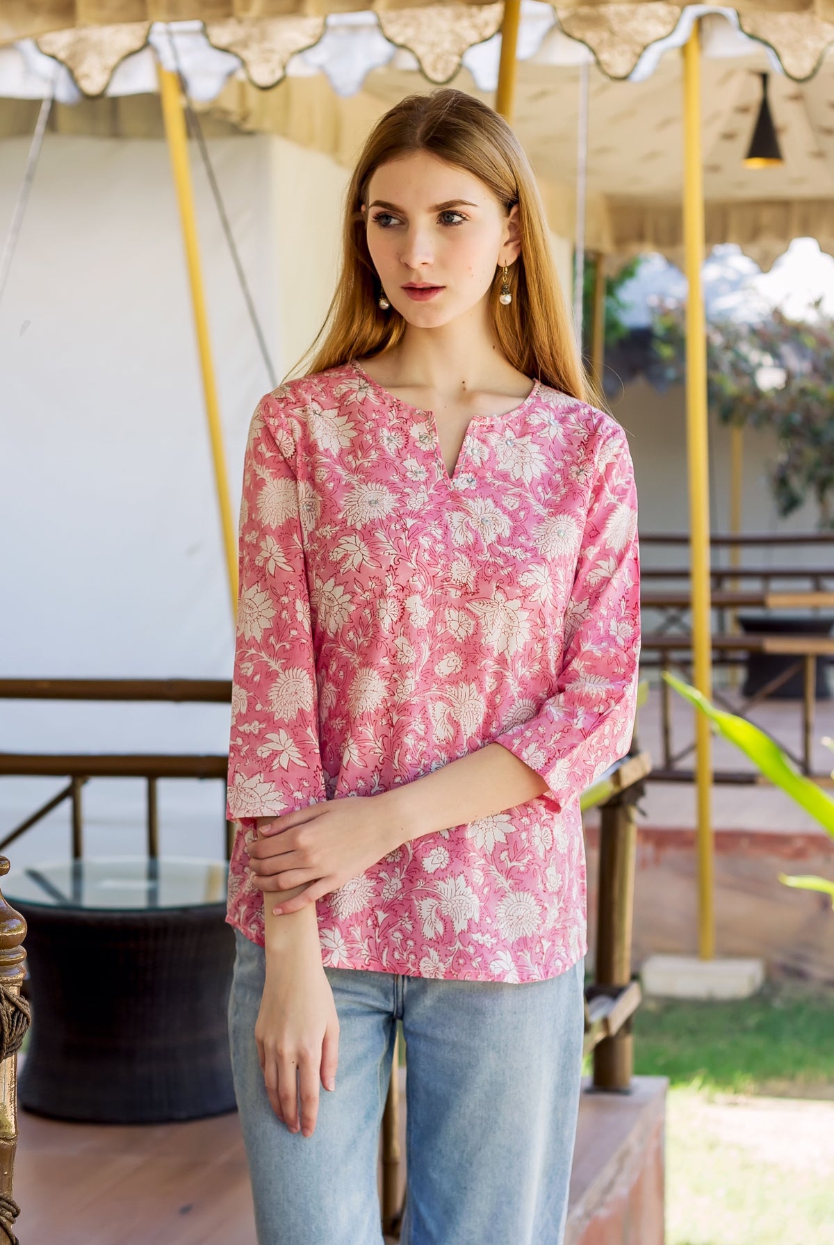 Model wears pink hand-block-printed ethnic top with white floral print and 3/4 sleeves.