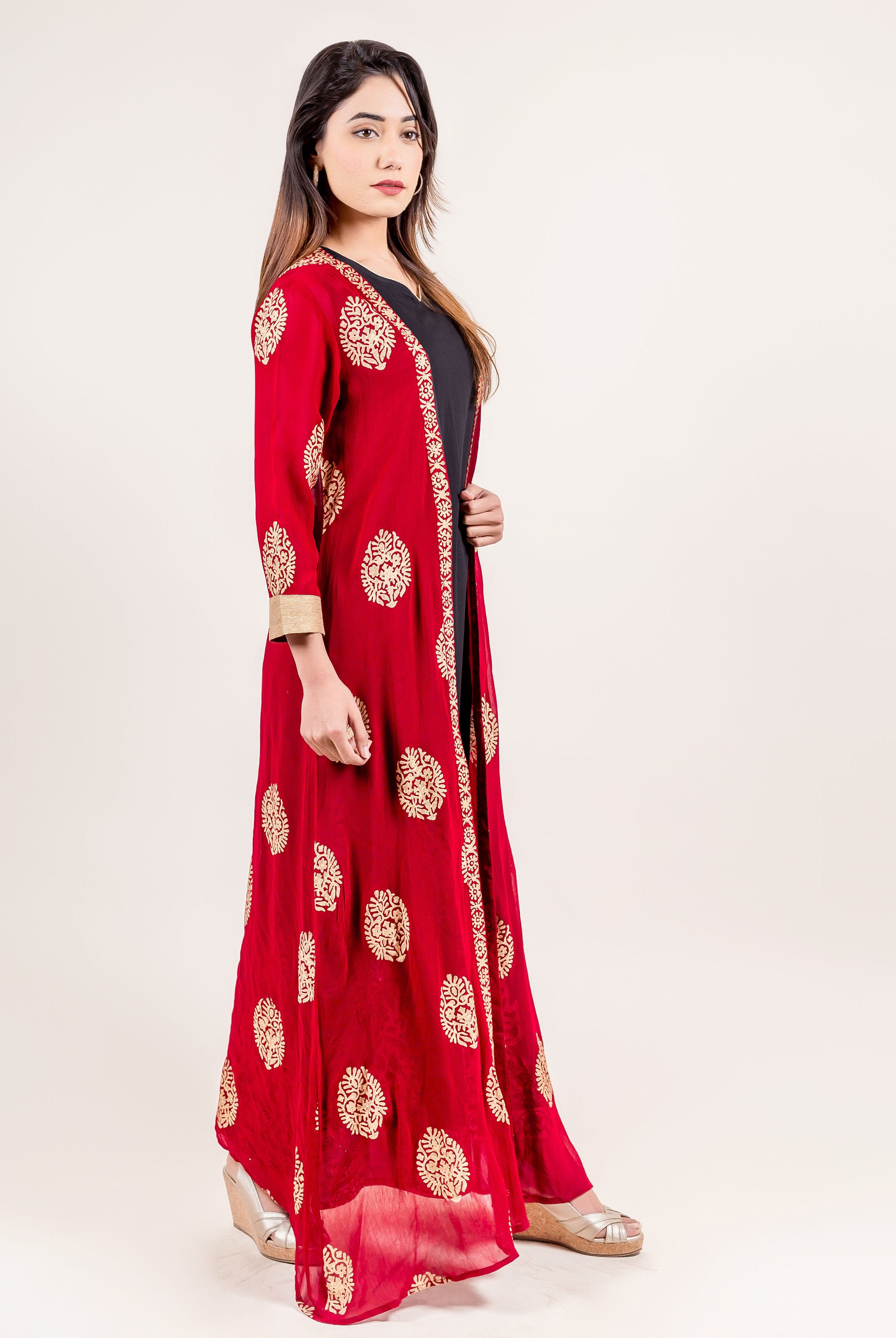 Side view of model in long red Indo Western jacket dress with gold print.