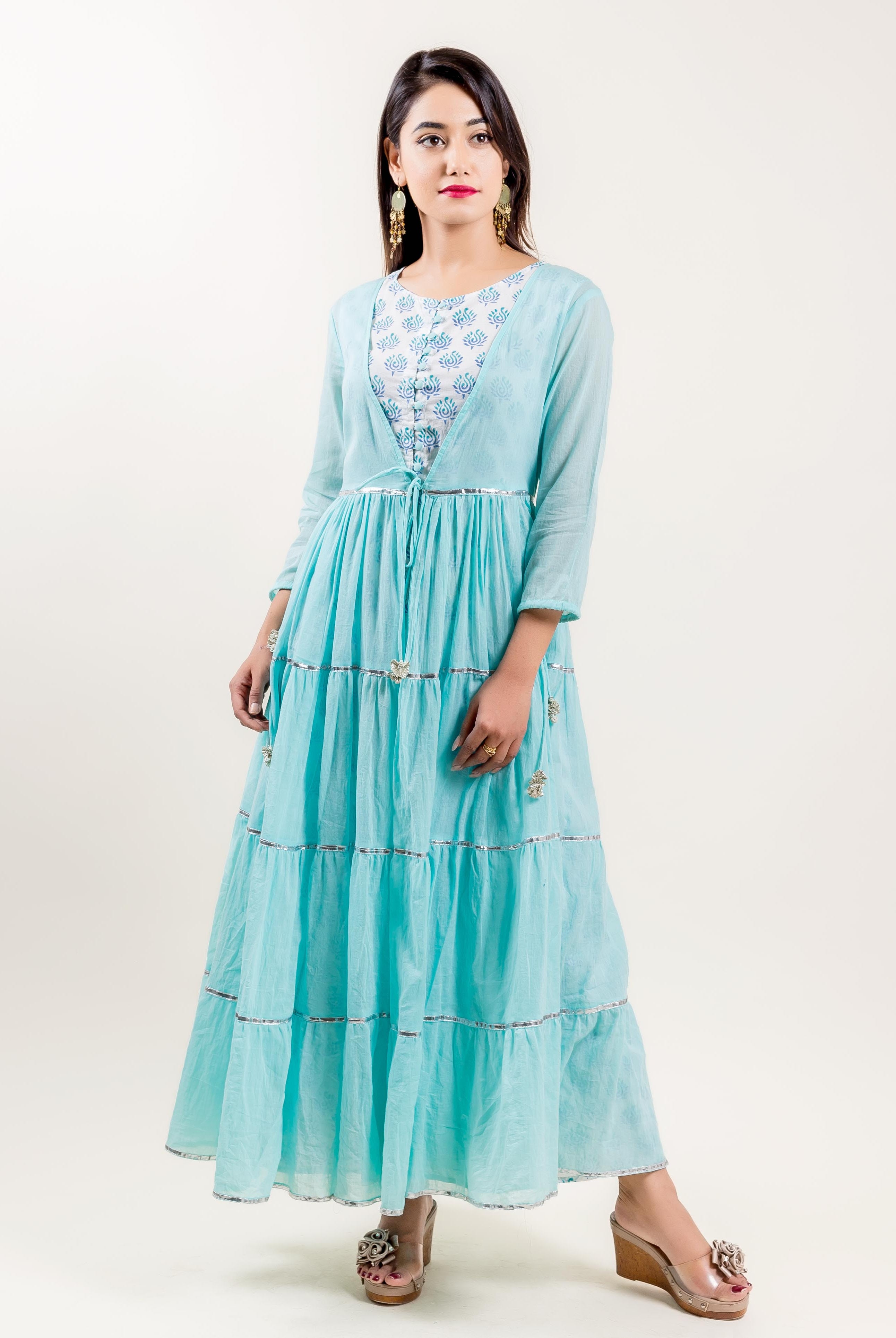 Front view of model in aqua tiered maxi dress with blue block-printed inner top.